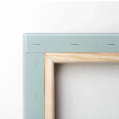 Corner close-up of natural wood frame and light blue canvas backing on wall art canvas.