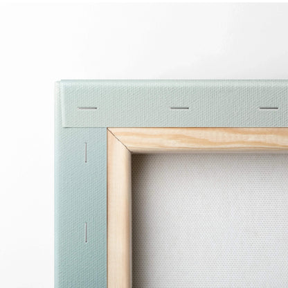 Close-up of wooden frame corner with stretched canvas and light green fabric backing for wall art canvas print.