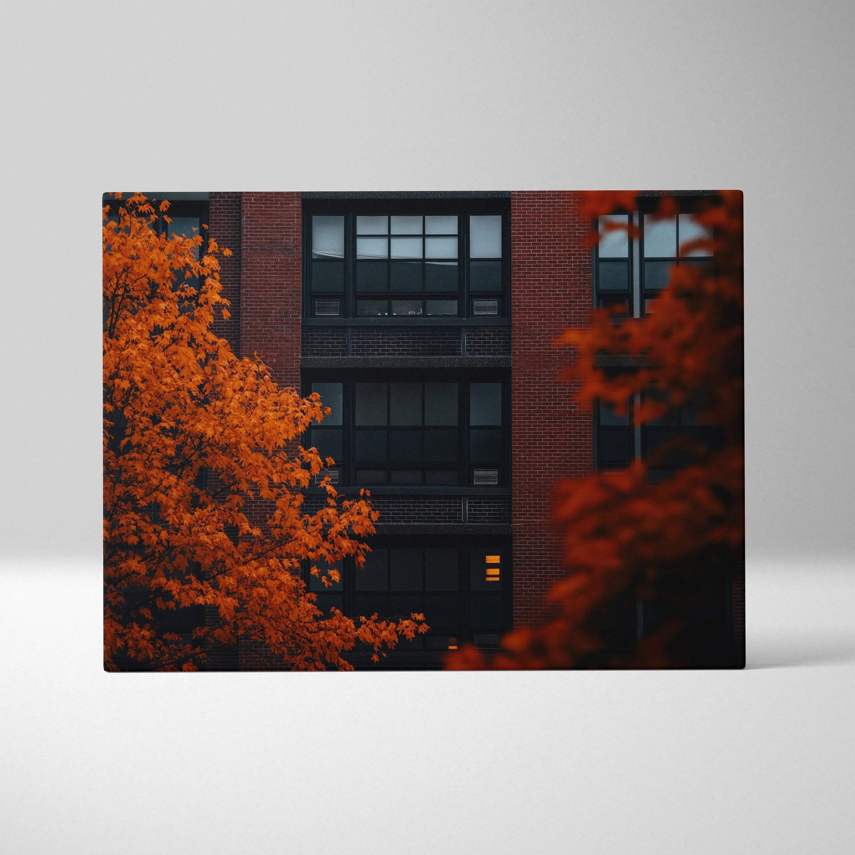 Canvas wall art featuring vibrant orange autumn leaves against dark urban building backdrop with window details.