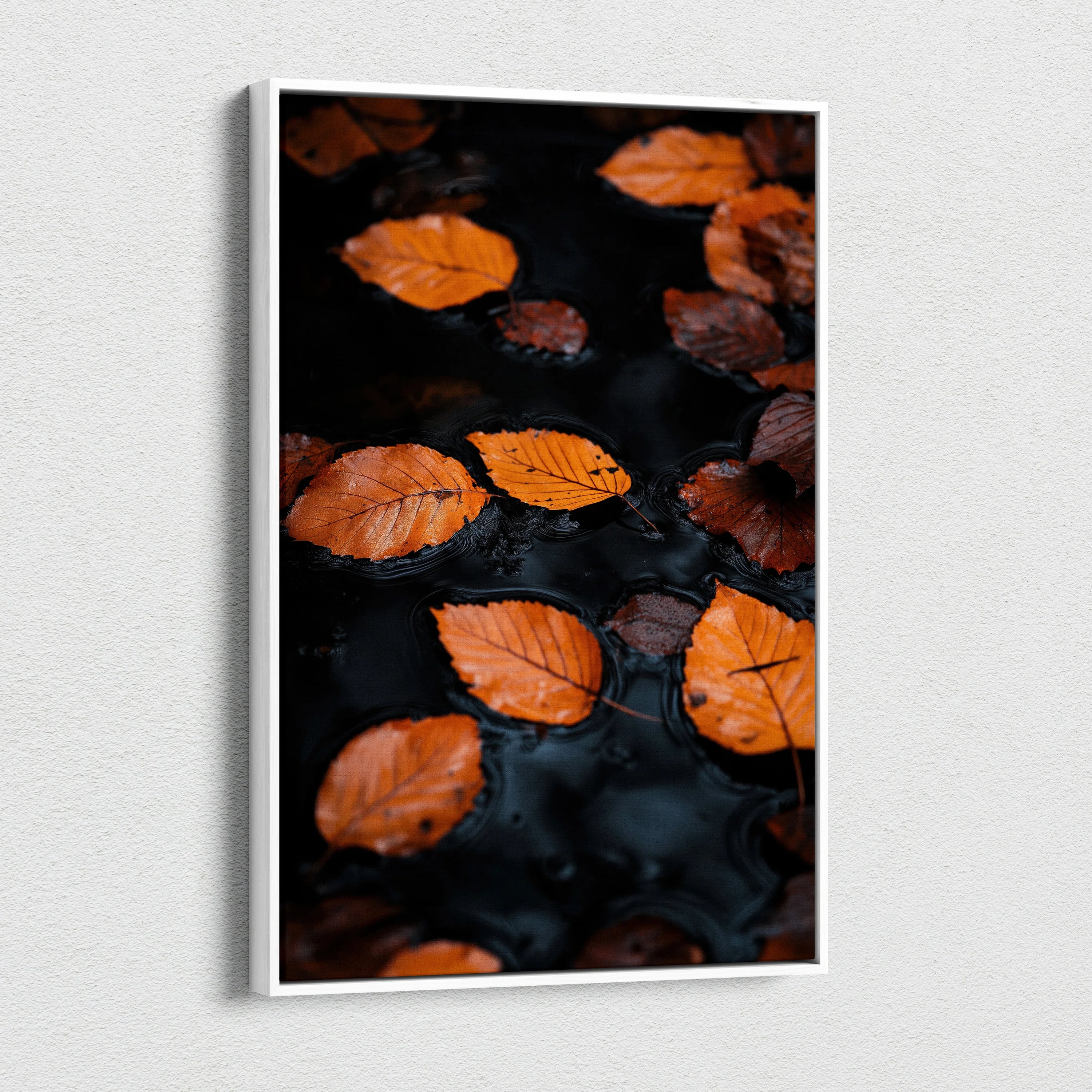 Minimalist autumn leaves floating on dark water canvas wall art with vibrant orange tones.
