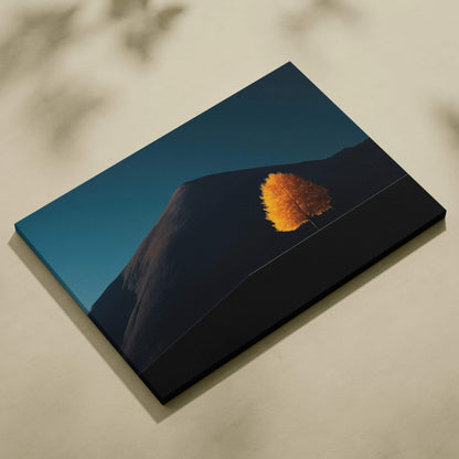 Minimalist canvas art featuring a single golden autumn tree on a dark hillside under a deep blue sky wall art.