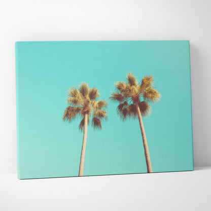 Canvas wall art featuring two tall palm trees against a vibrant turquoise sky background.
