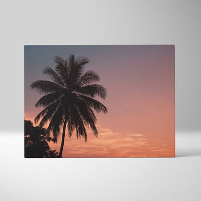 Canvas wall art featuring a silhouette of a palm tree against a vibrant tropical sunset sky in shades of orange, pink, and.