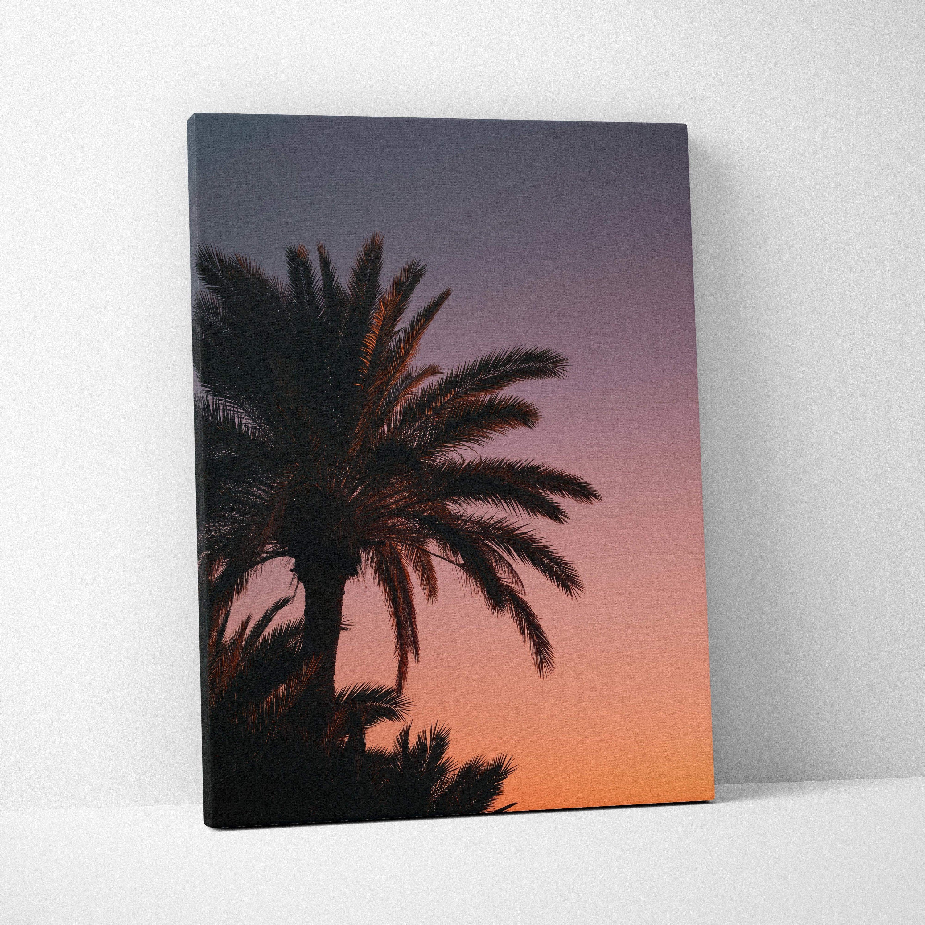 Canvas wall art featuring a black palm tree silhouette against a vibrant orange and purple tropical sunset sky.