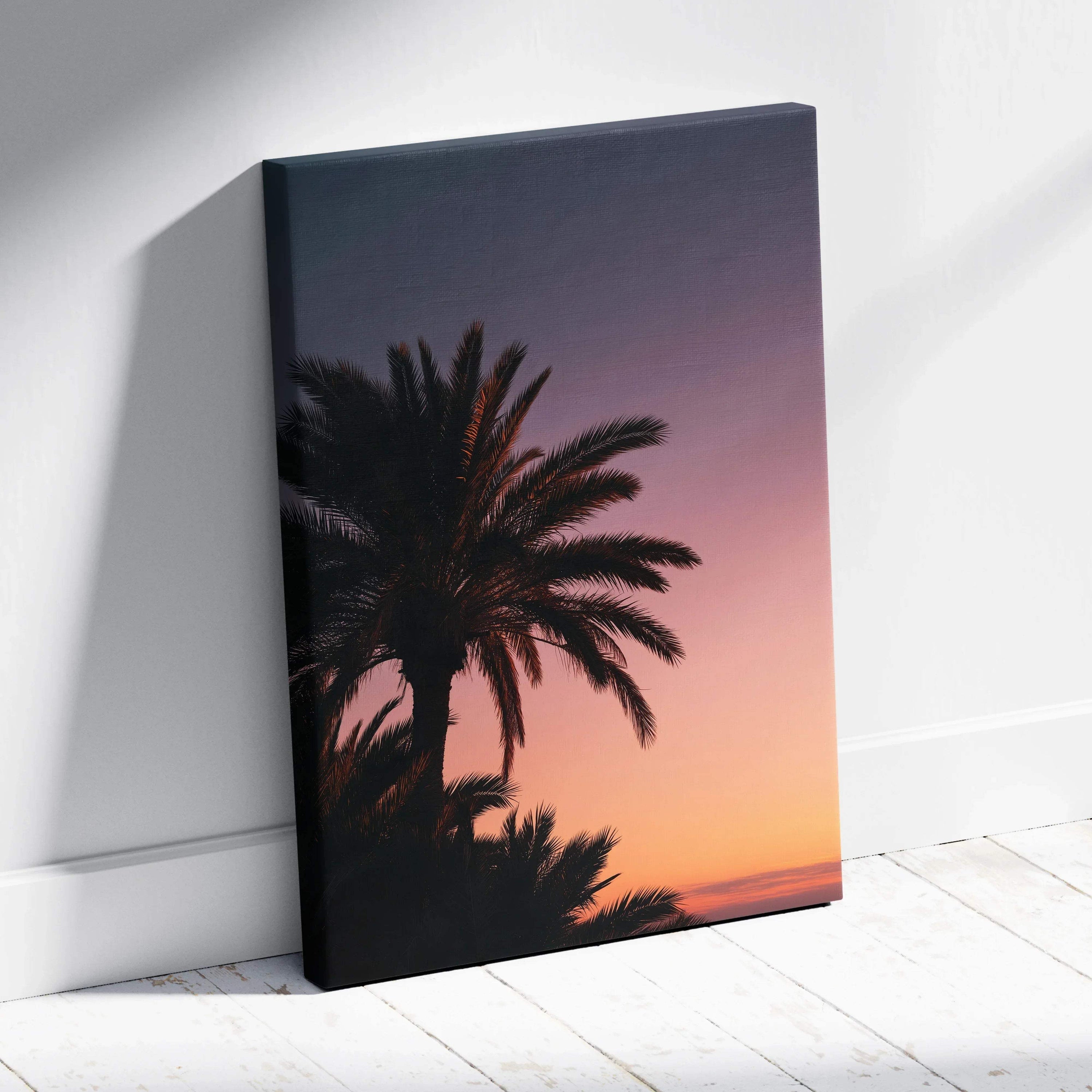 Canvas wall art featuring a dark palm tree silhouette against a gradient tropical sunset sky in warm orange and purple tones.