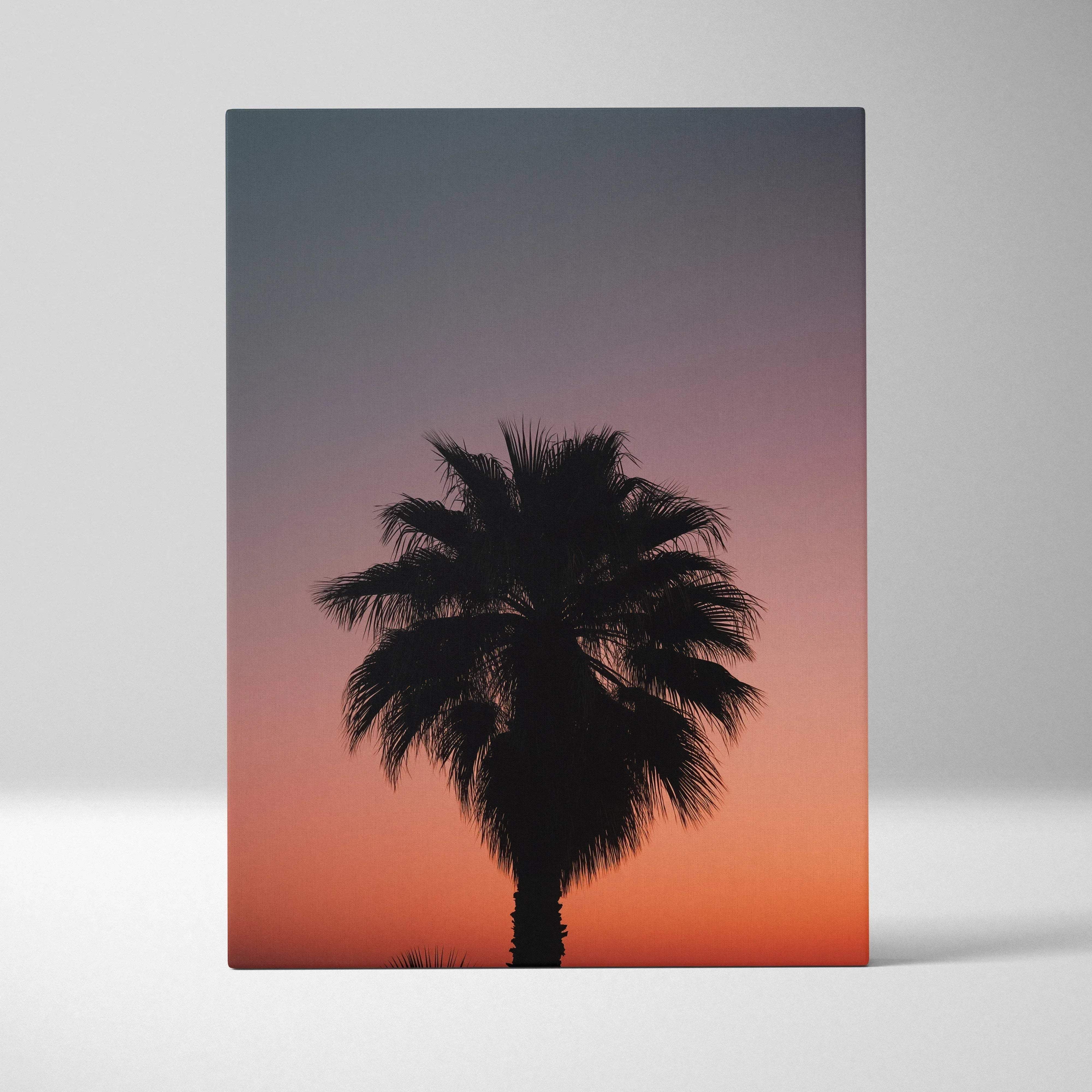 Palm tree silhouette canvas wall art featuring a black palm tree against a warm dusk gradient sunset sky for tropical decor