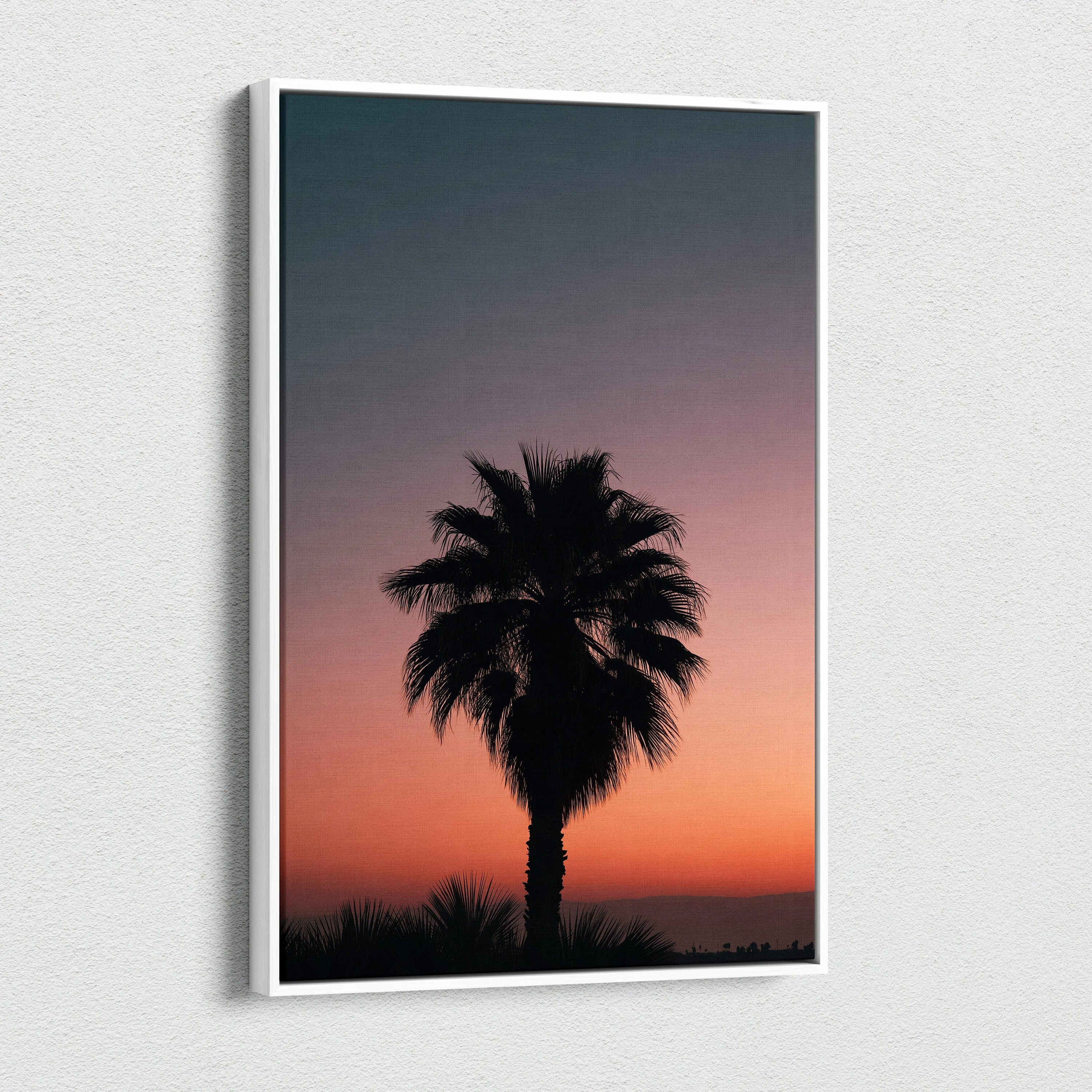 Canvas wall art featuring a black tropical palm tree silhouette against a vibrant orange and purple dusk sky.
