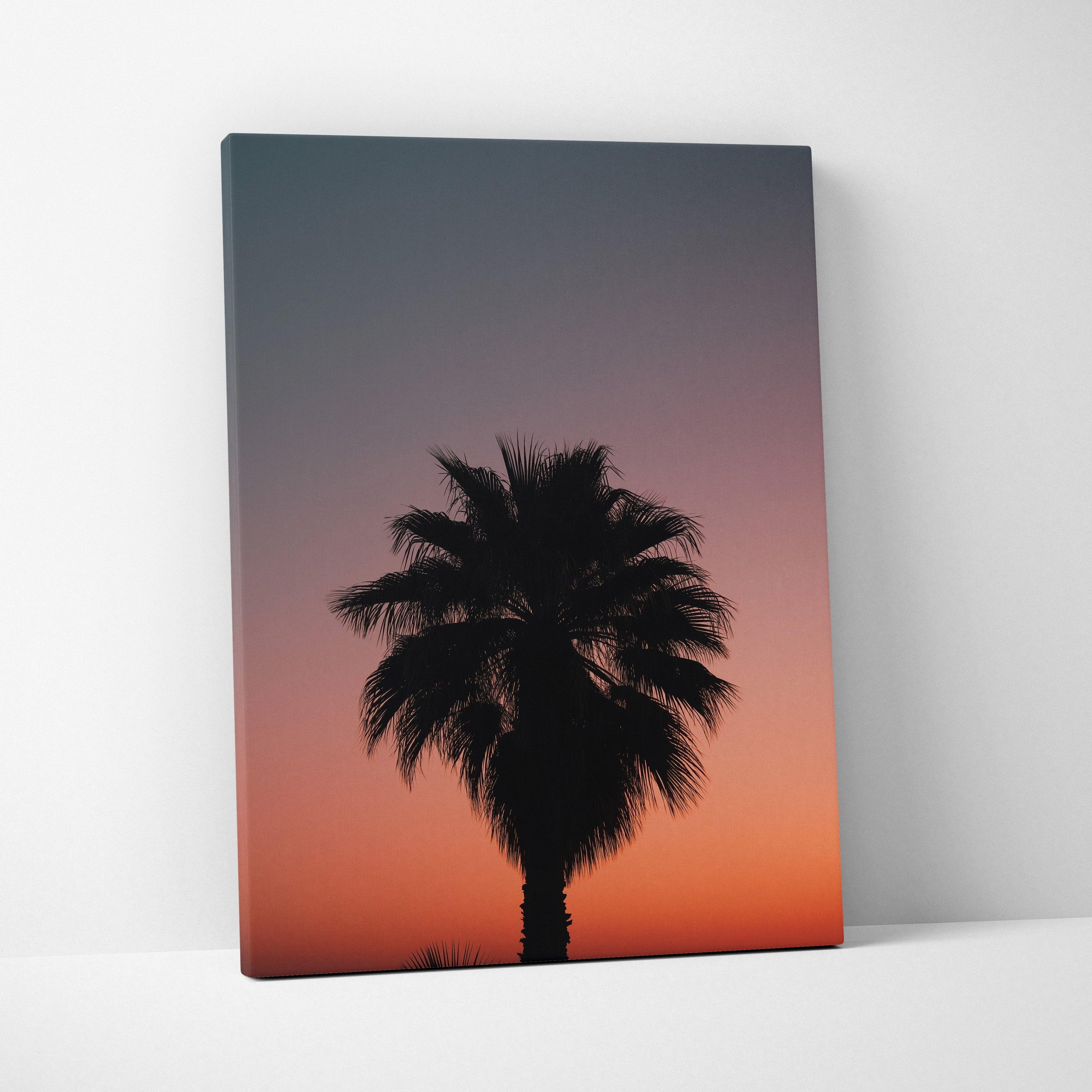 Canvas wall art featuring a black tropical palm tree silhouette against a gradient dusk sky with deep blue and warm orange.