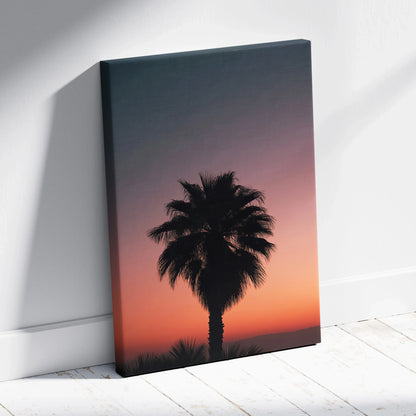 Canvas wall art featuring a black palm tree silhouette against a gradient dusk sky in orange and purple tones.