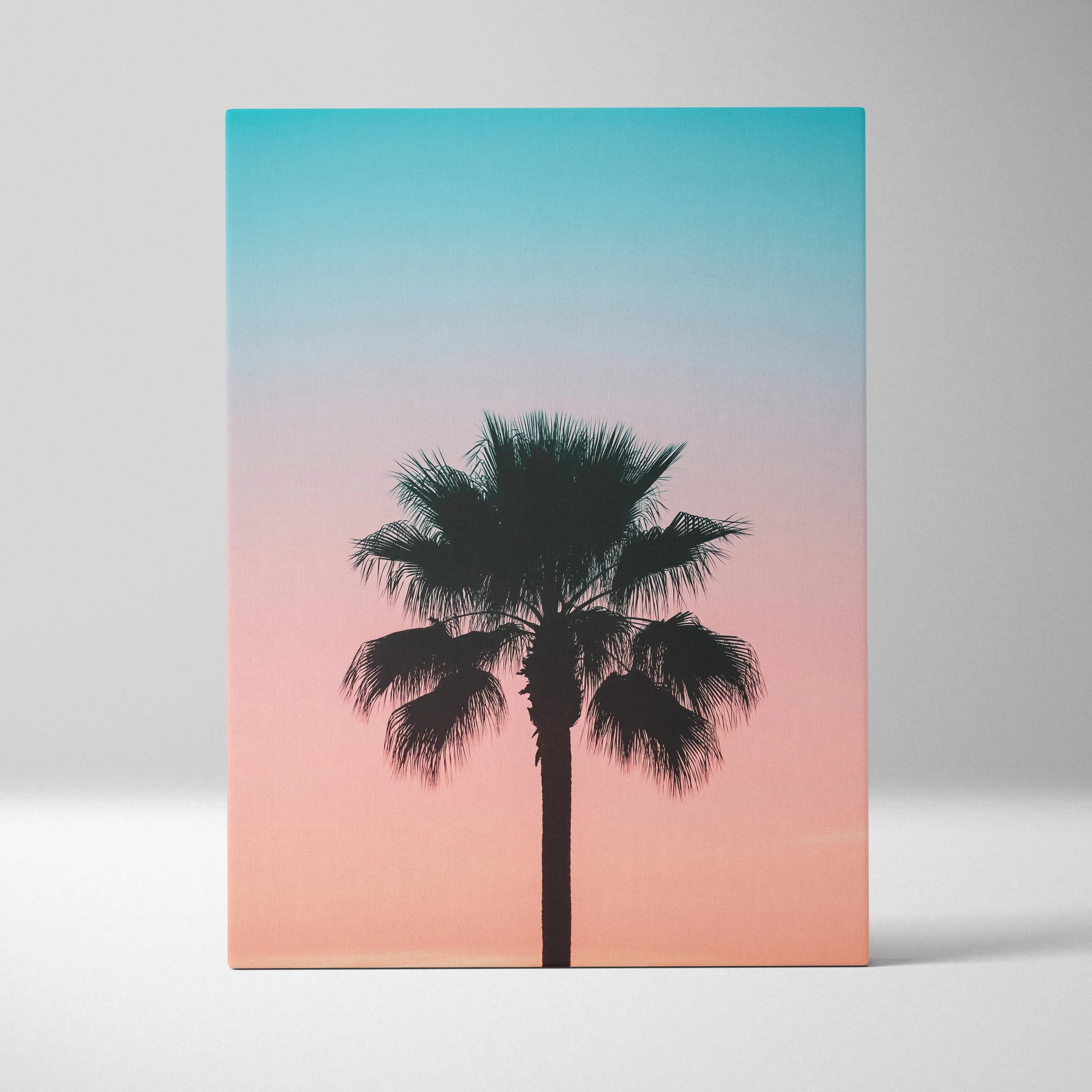 Canvas wall art featuring a black palm tree silhouette against a vivid pink and blue sunset sky decor.