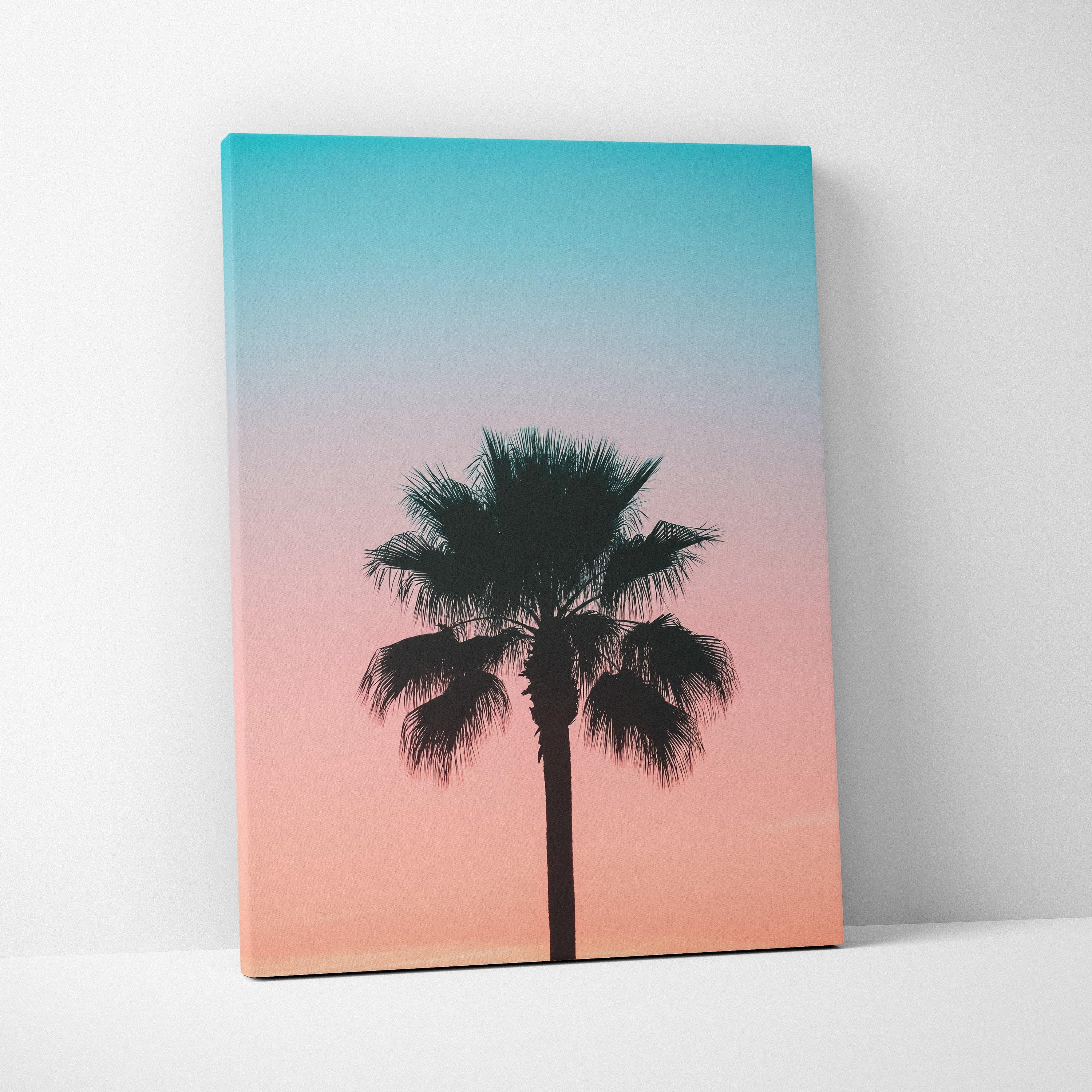 Canvas wall art featuring a black palm tree silhouette against a gradient sunset sky in blue and peach tones.