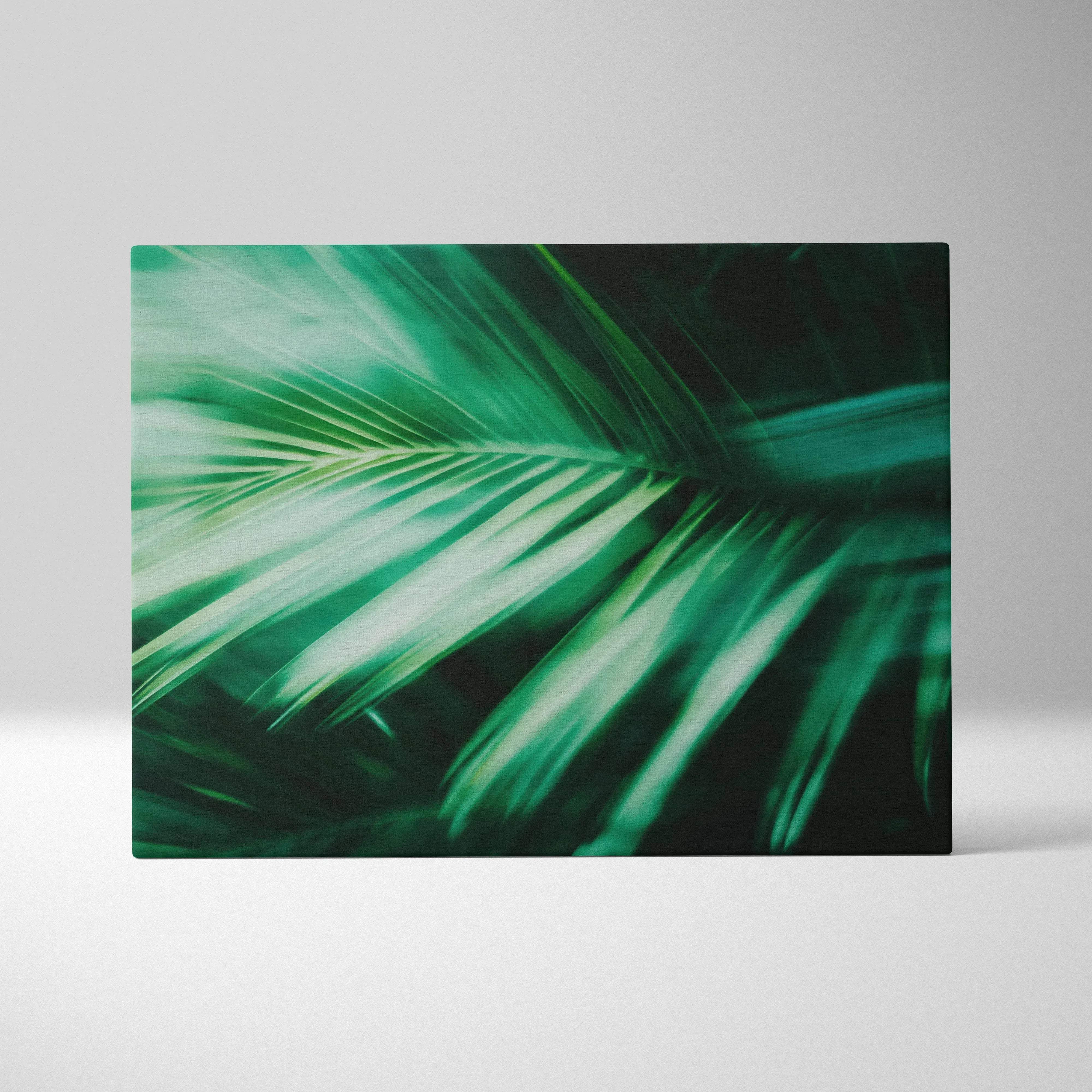 A rectangular canvas print featuring a vibrant green palm leaf with motion blur in emerald green teal tropical decor