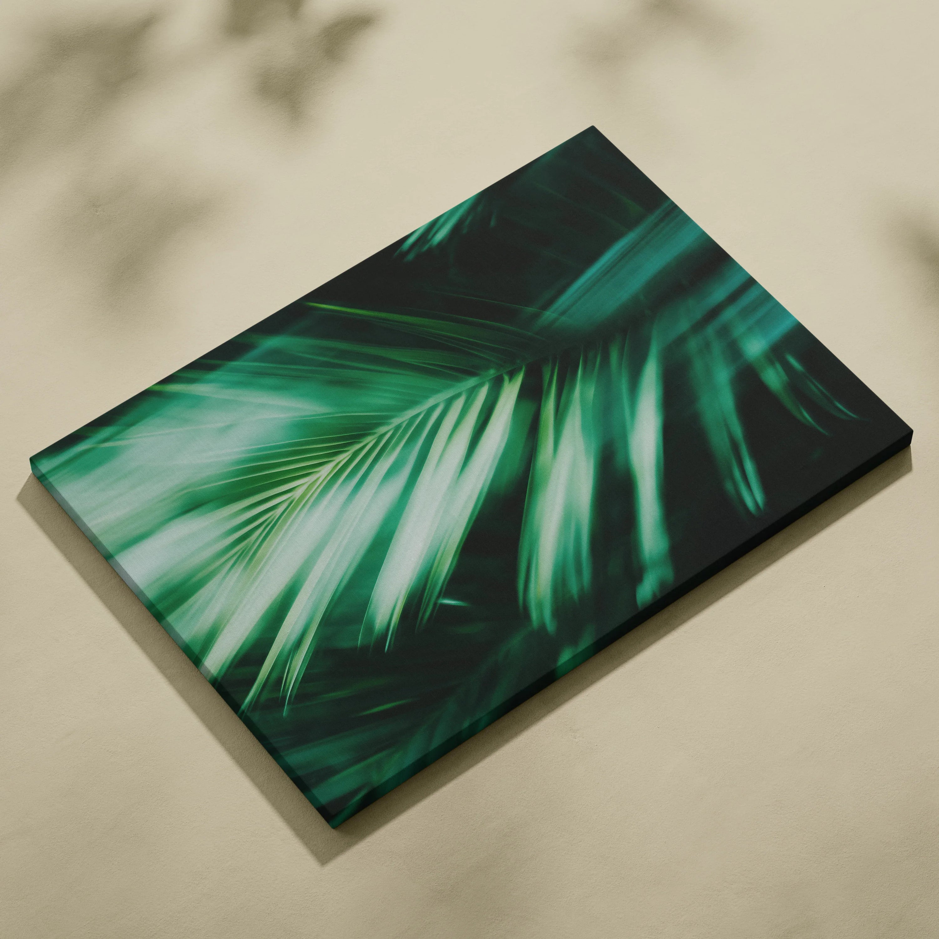 Green tropical palm leaves close-up on rectangular canvas wall art with a smooth finish and muted beige background.