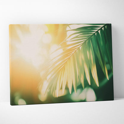 Canvas wall art featuring digital tropical palm leaves bathed in a warm sunlit golden glow.