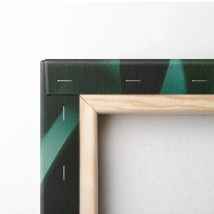Corner of stretched canvas wall art showing wooden frame and dark green tropical leaf design with golden sun flare accents.
