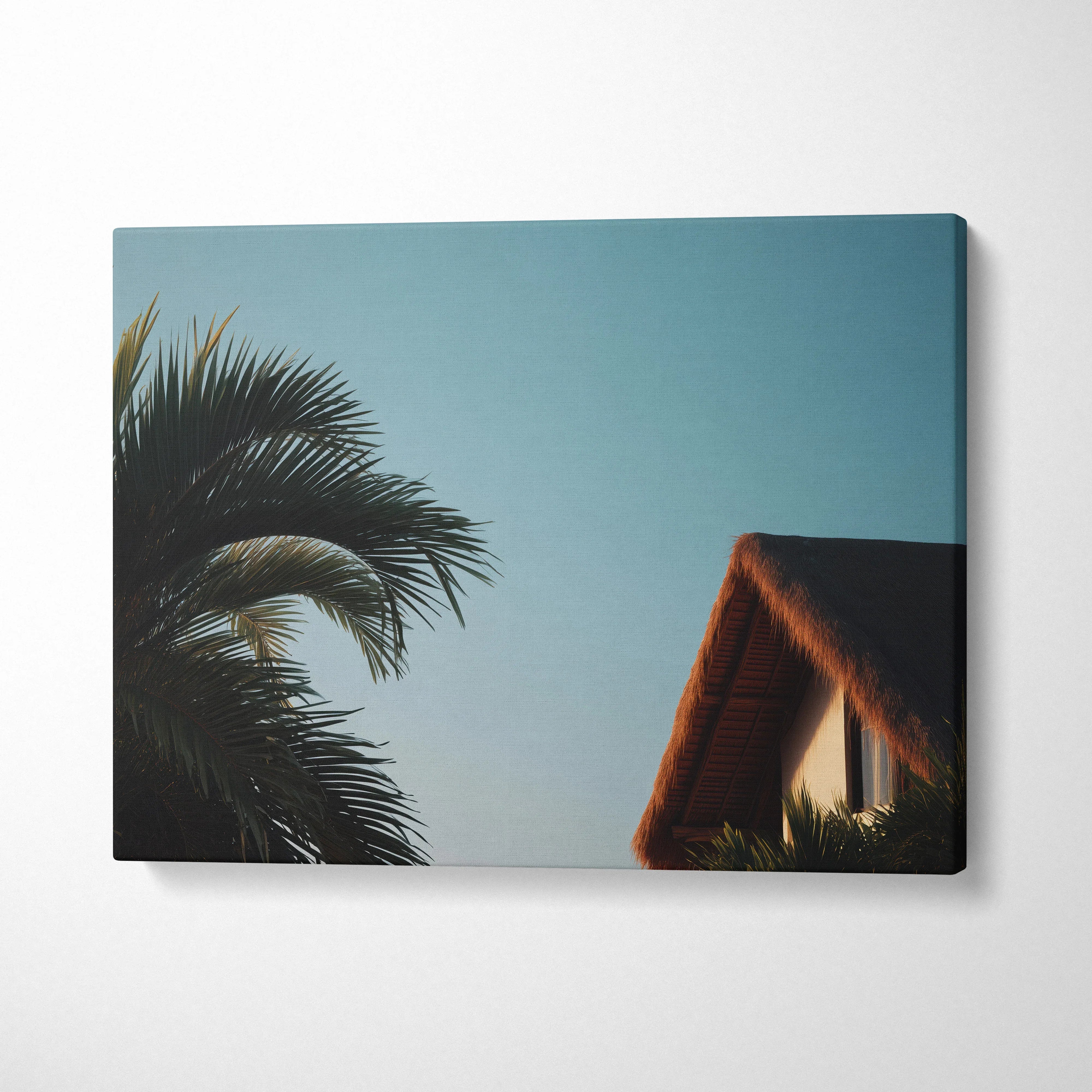 Tropical palm trees and thatched roof house digital art on canvas wall decor with blue sky background.
