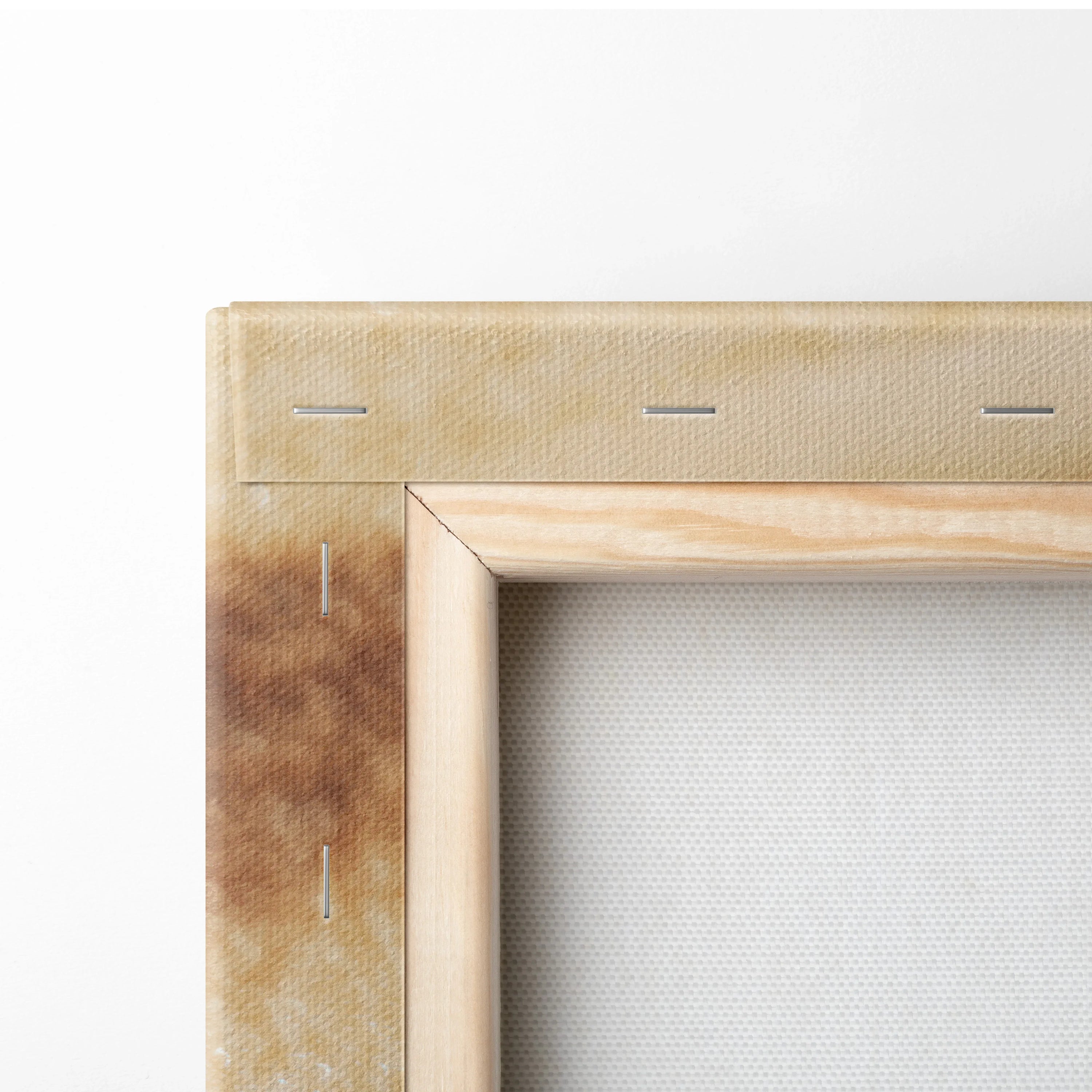 Close-up of wooden canvas frame corner with beige fabric stretched over wood for wall art decor.