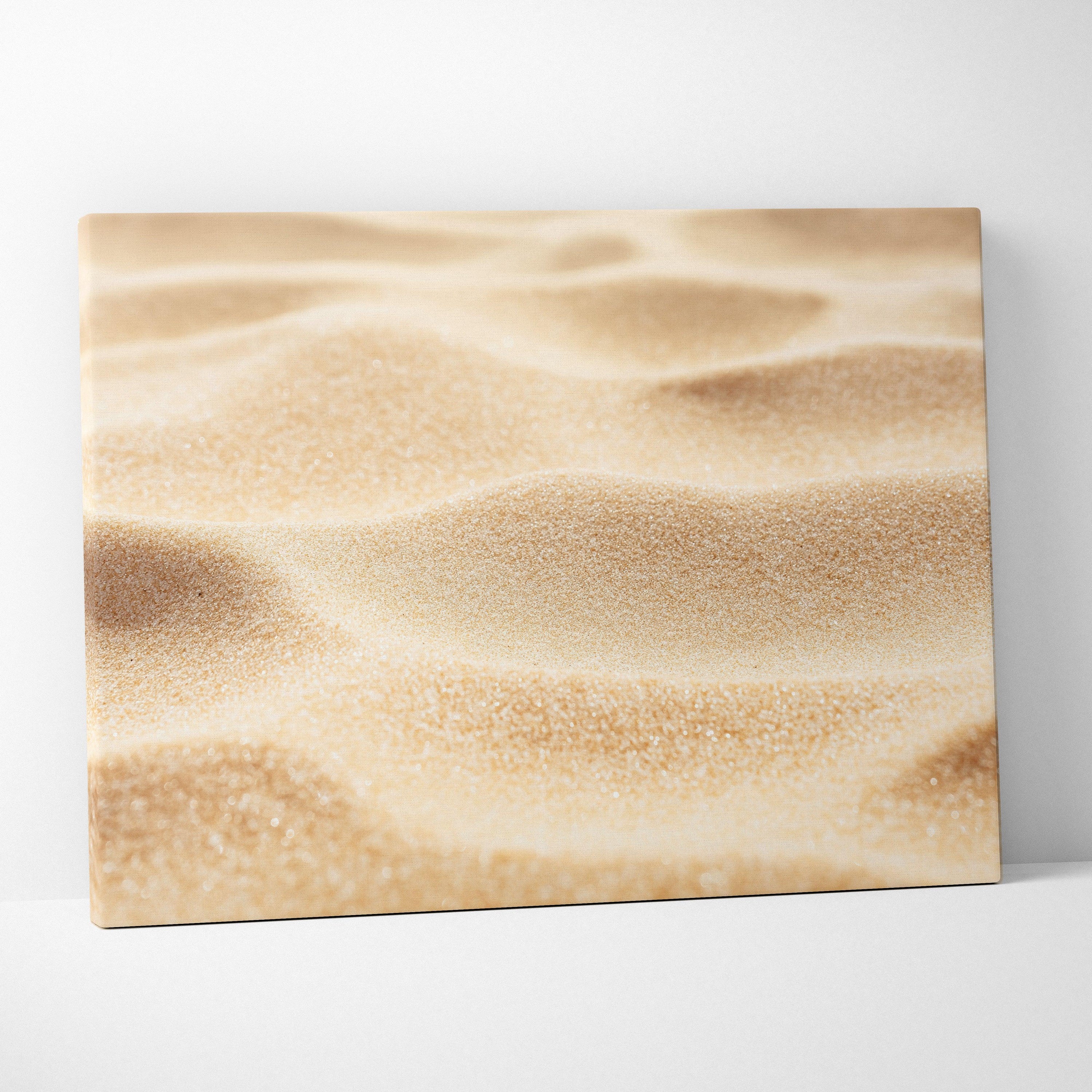 Canvas wall art featuring a close-up of smooth golden beach sand texture with soft shadows and warm tones.