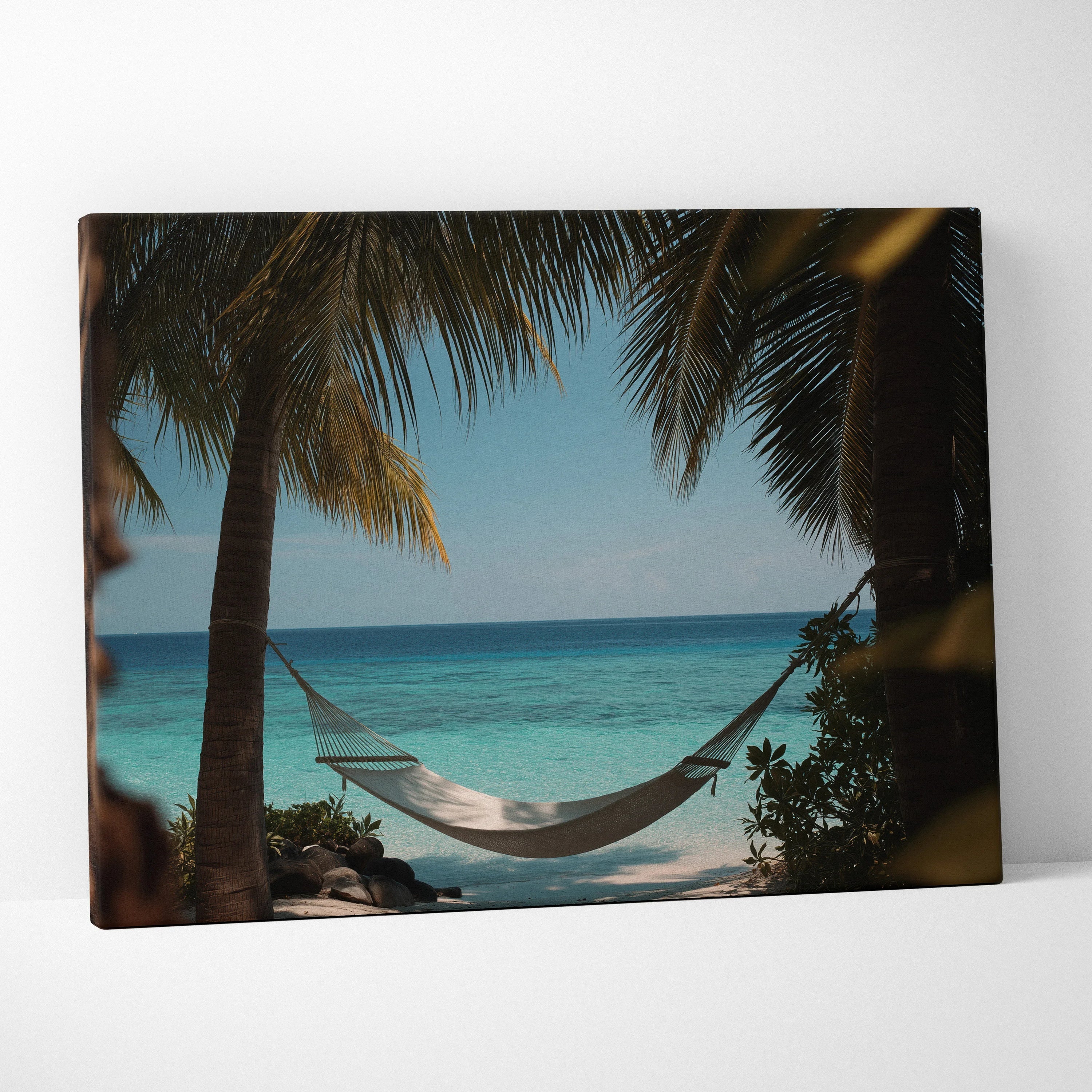 Canvas wall art featuring a white hammock strung between palm trees with a turquoise ocean and blue sky background.