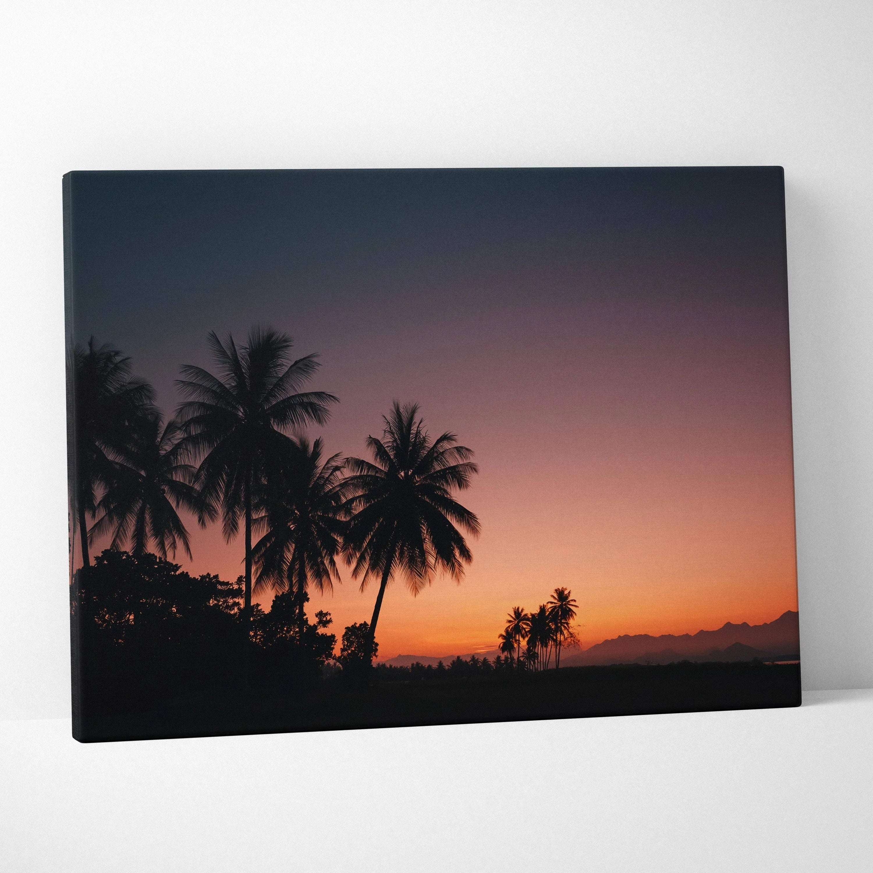 Canvas wall art featuring silhouetted palm trees against a vivid tropical sunset sky in deep orange and purple hues.