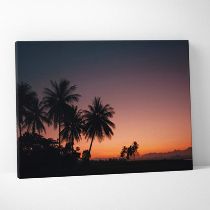 Canvas wall art featuring silhouetted palm trees against a vivid tropical sunset sky in deep orange and purple hues.