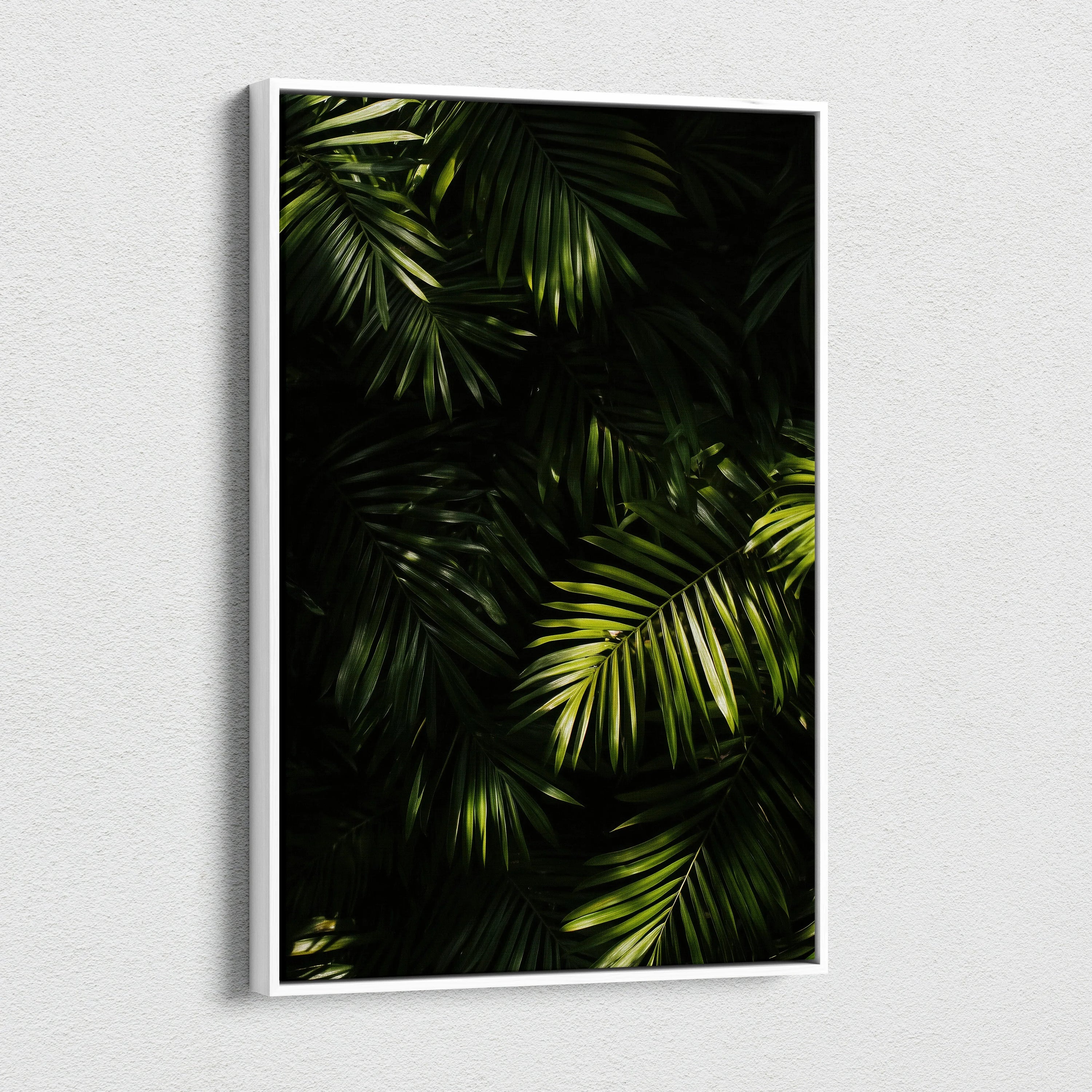 Canvas wall art featuring lush green tropical palm leaves with contrasting dark shadows.