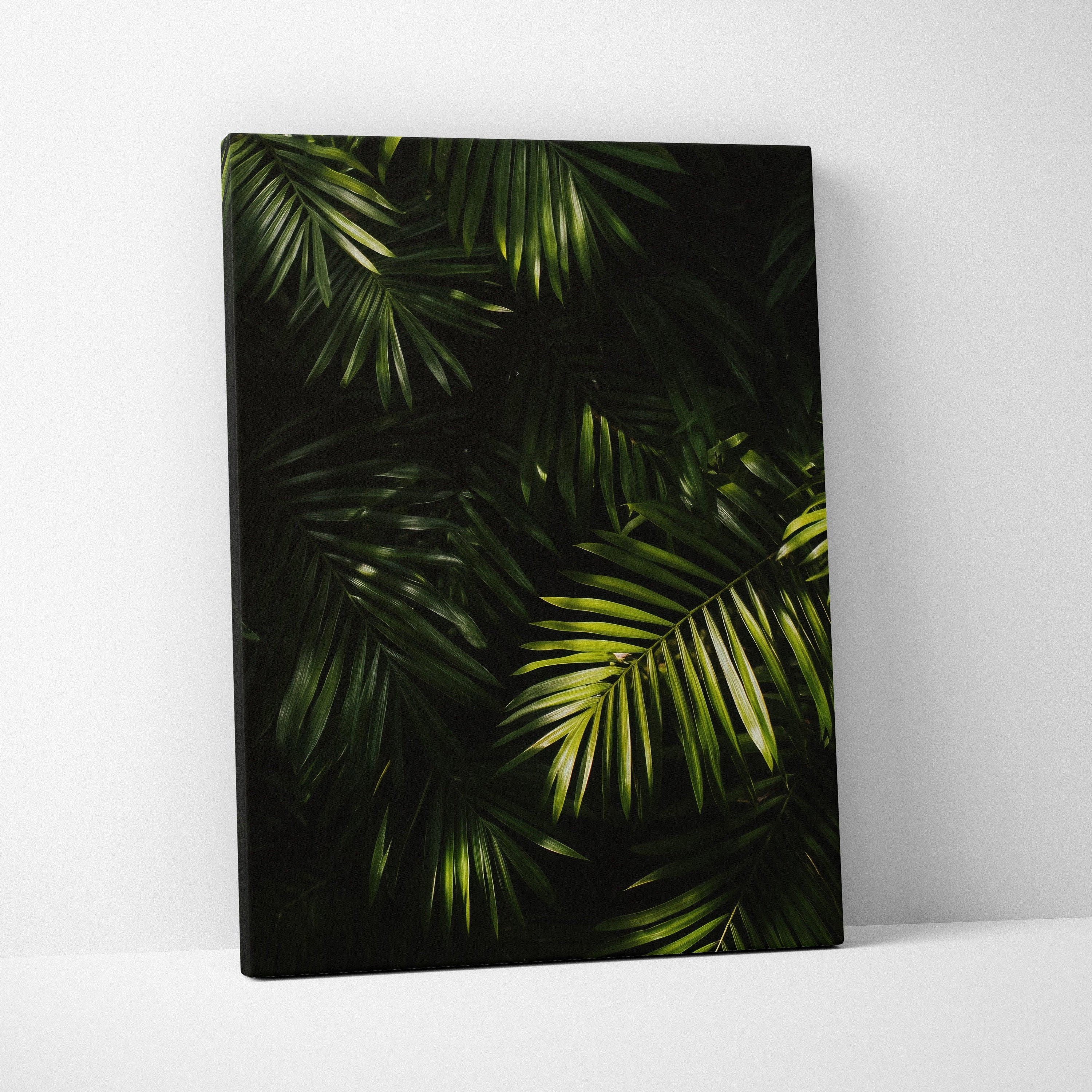 Canvas wall art featuring lush green tropical palm leaves with dark, moody background decor.