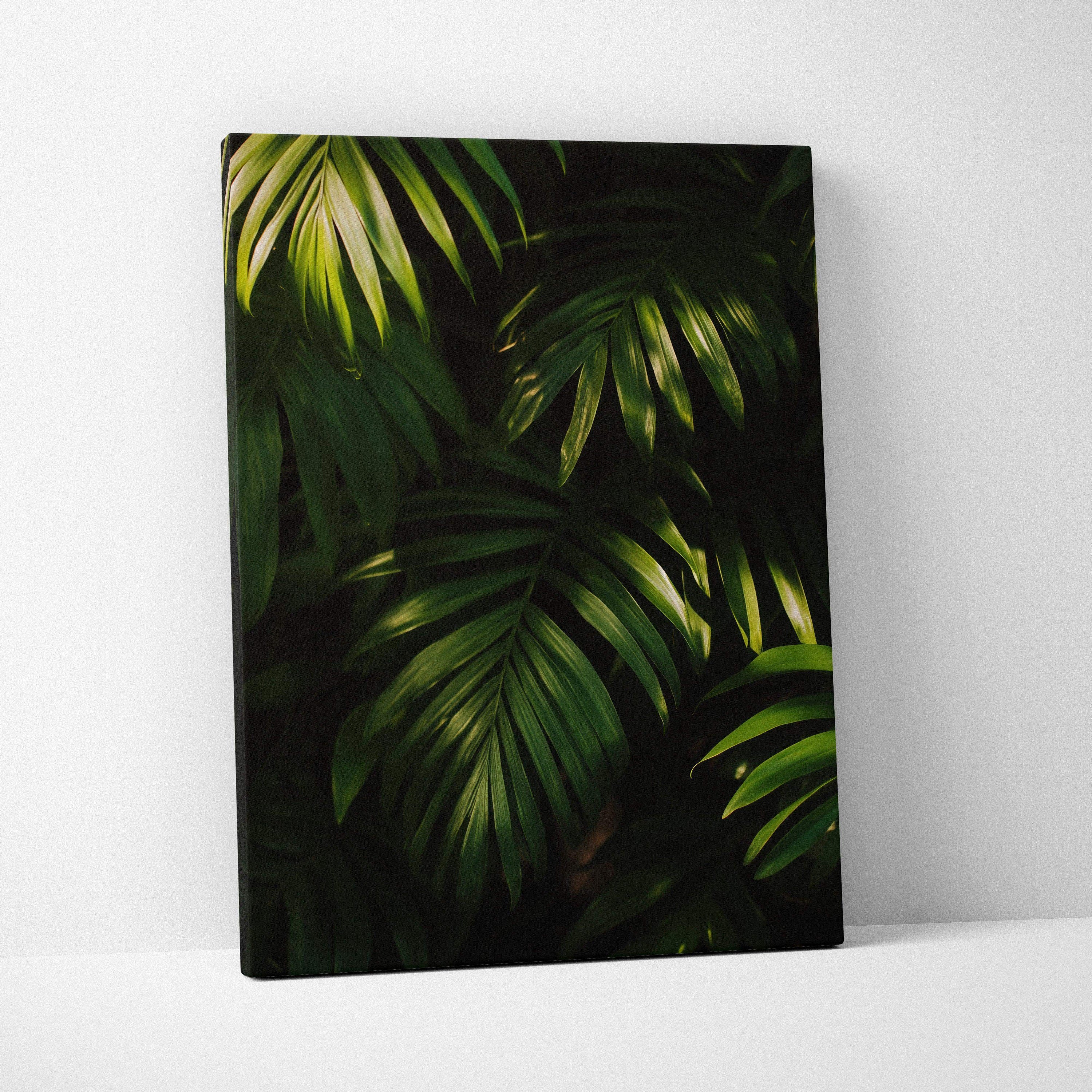 Canvas wall art featuring dark green tropical leaves with light accents against a black background.