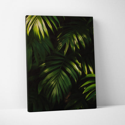 Canvas wall art featuring dark green tropical leaves with light accents against a black background.
