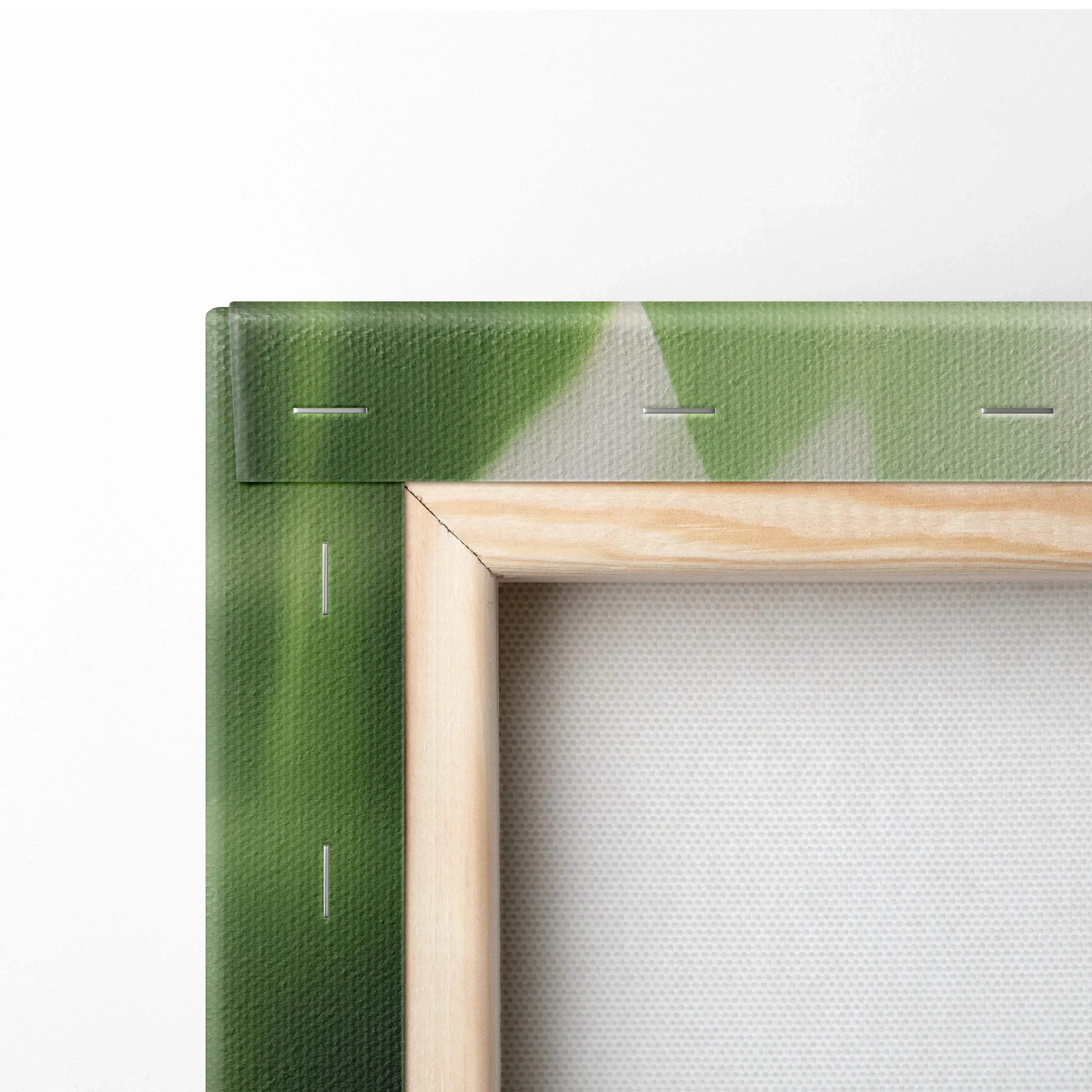 Close-up of green tropical leaf canvas wall art corner with wooden frame and visible fabric texture.