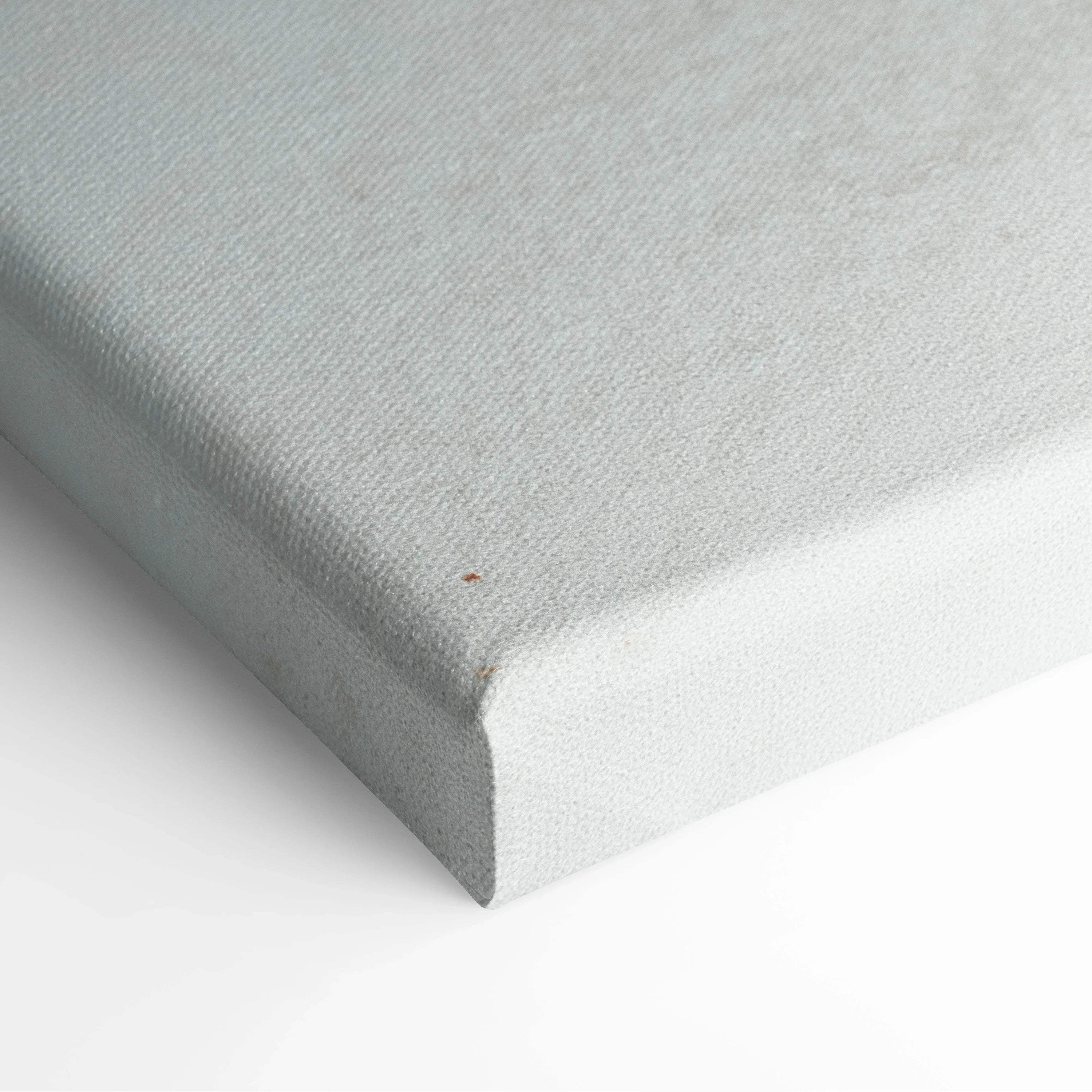 Close-up of white textured canvas stretched over wooden frame, showcasing clean edge and fine fabric weave.