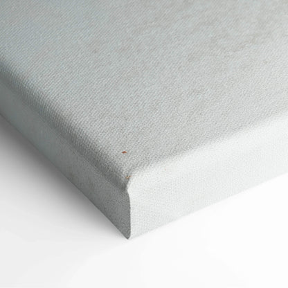 Close-up of white textured canvas stretched over wooden frame, showcasing clean edge and fine fabric weave.
