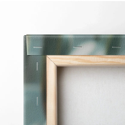 Close-up of wooden frame corner and green-blue canvas backing with visible staples for wall art decor.