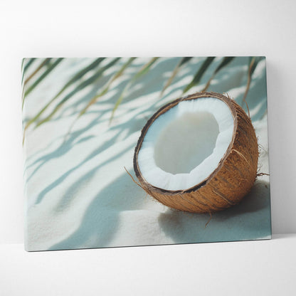 Canvas wall art featuring a close-up of a cracked coconut on soft sand with palm leaf shadows.