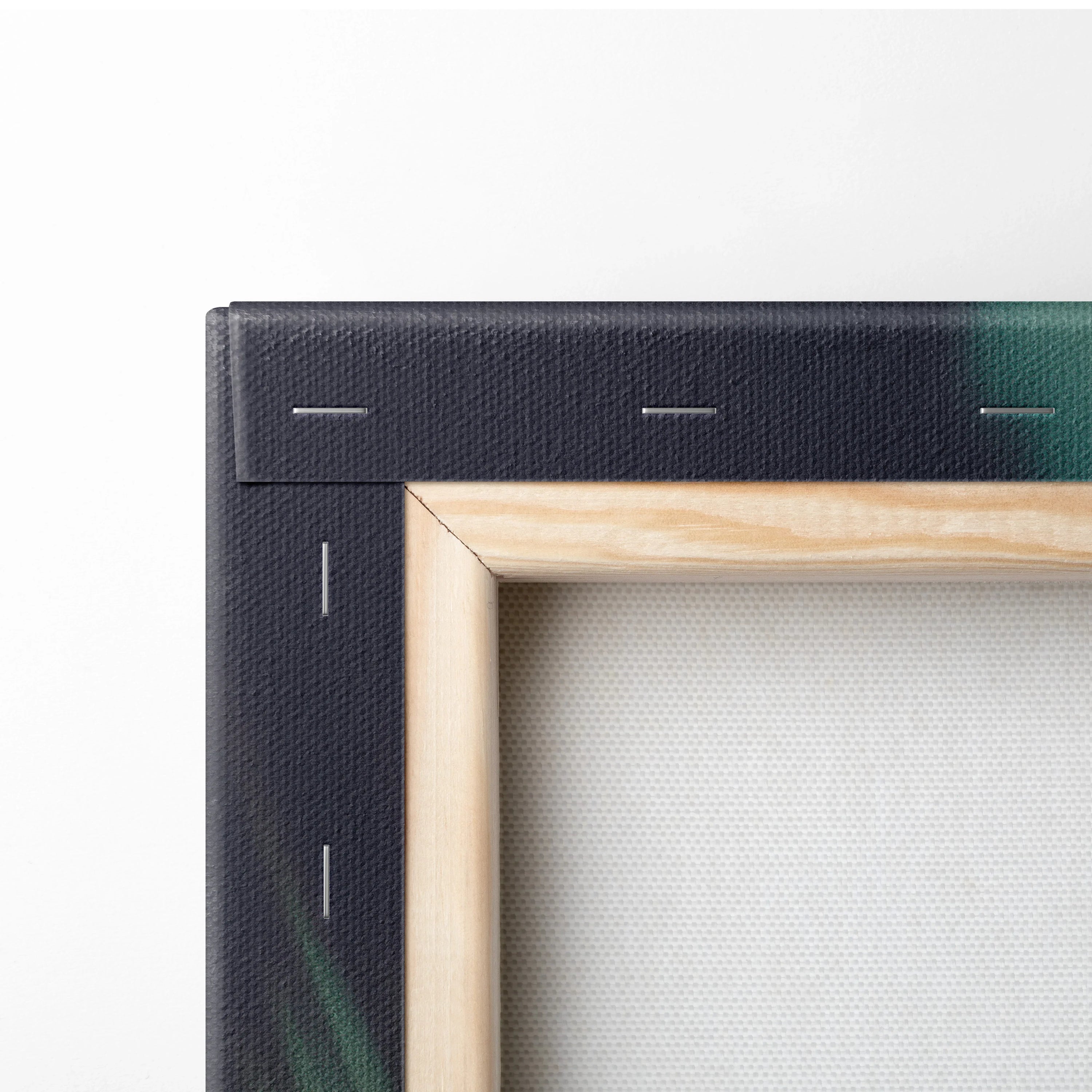 Corner view of a stretched canvas with wooden frame and black painted edge showing green and blue hues.