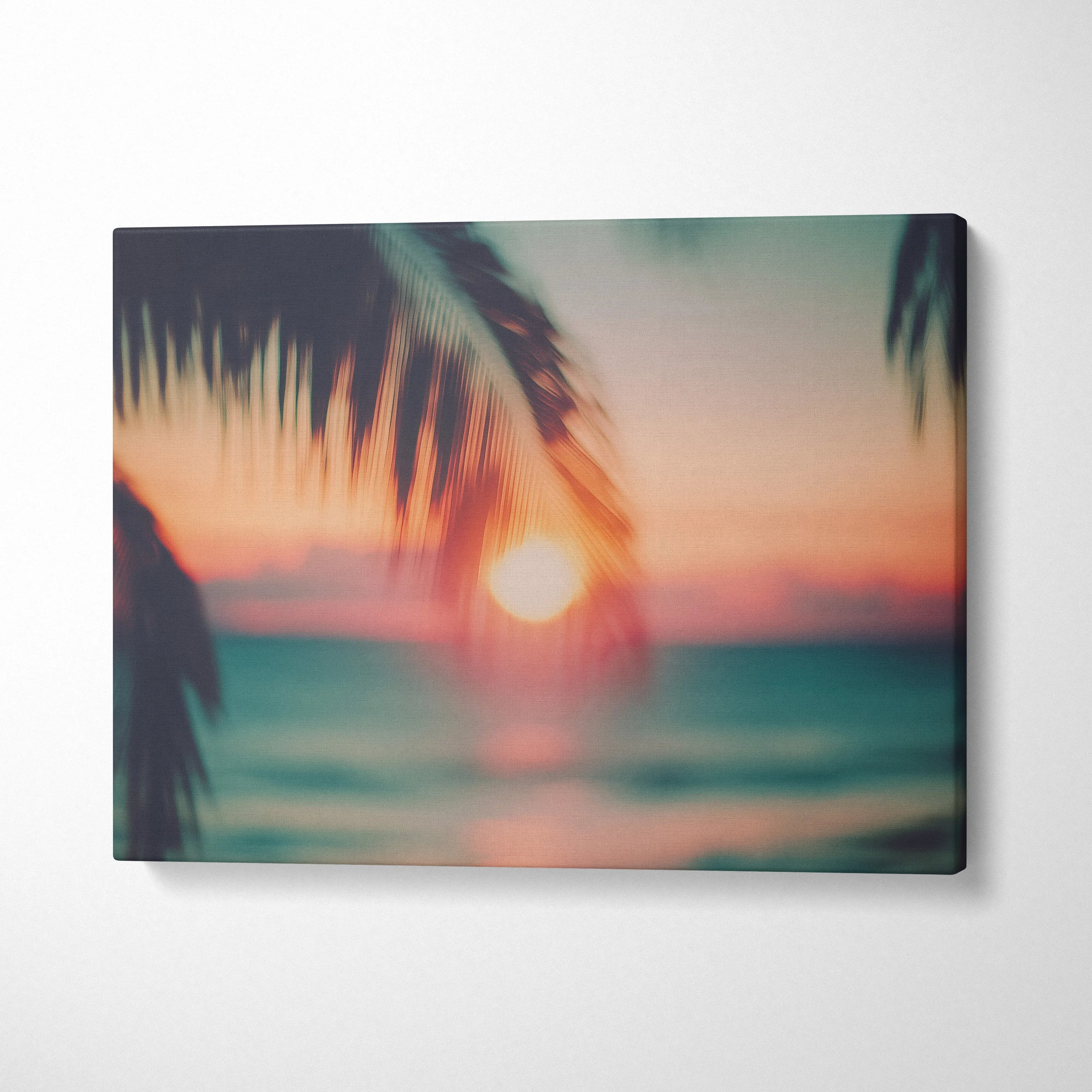 Canvas wall art featuring blurred tropical sunset with silhouette palm leaves in warm tones for home decor.