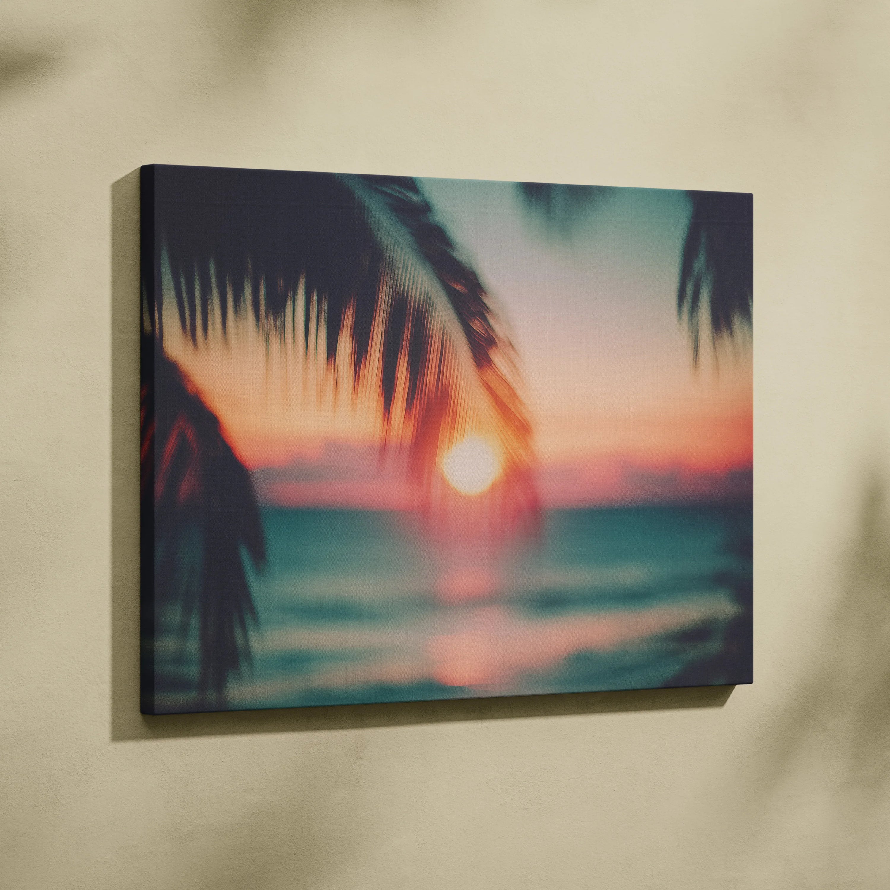 Canvas wall art featuring a blurred tropical sunset with silhouette palm leaves and ocean waves.