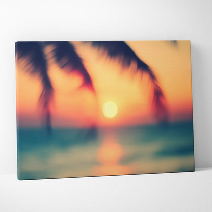 Canvas wall art featuring a blurred tropical sunset with palm tree silhouettes and glowing orange ocean reflections.