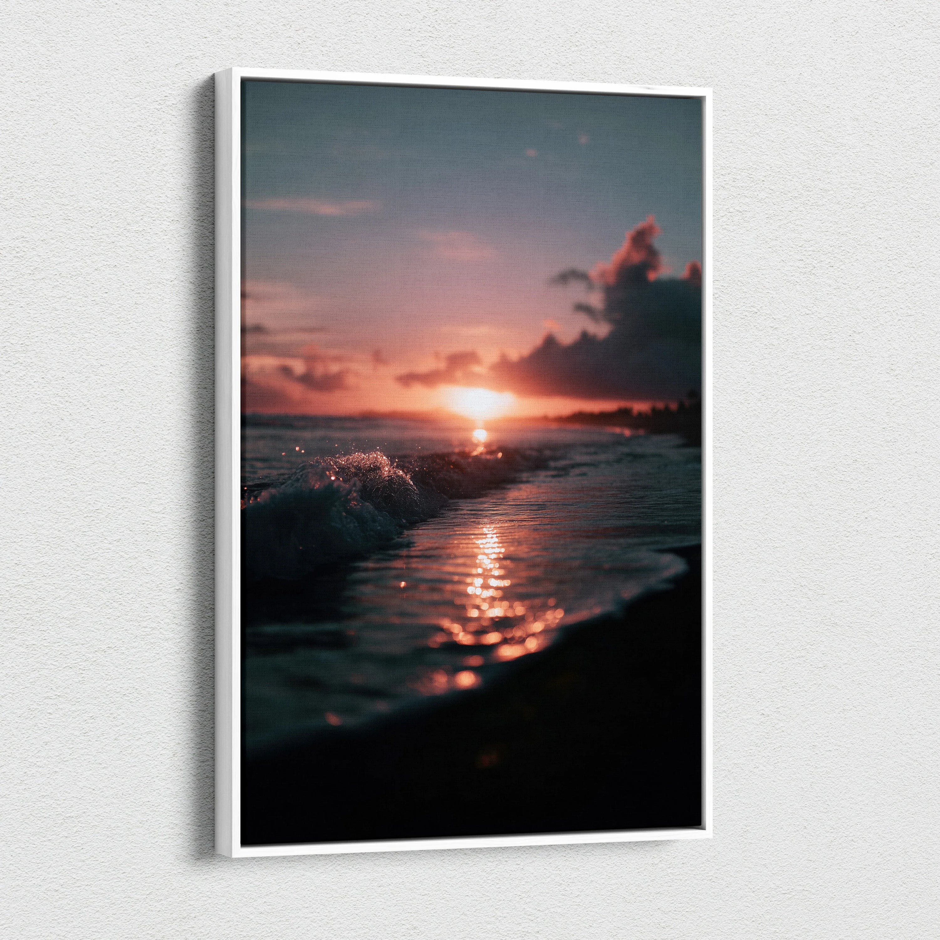 Canvas wall art of a tropical sunset with glowing orange sun over dark beach waves and silhouette palm trees.