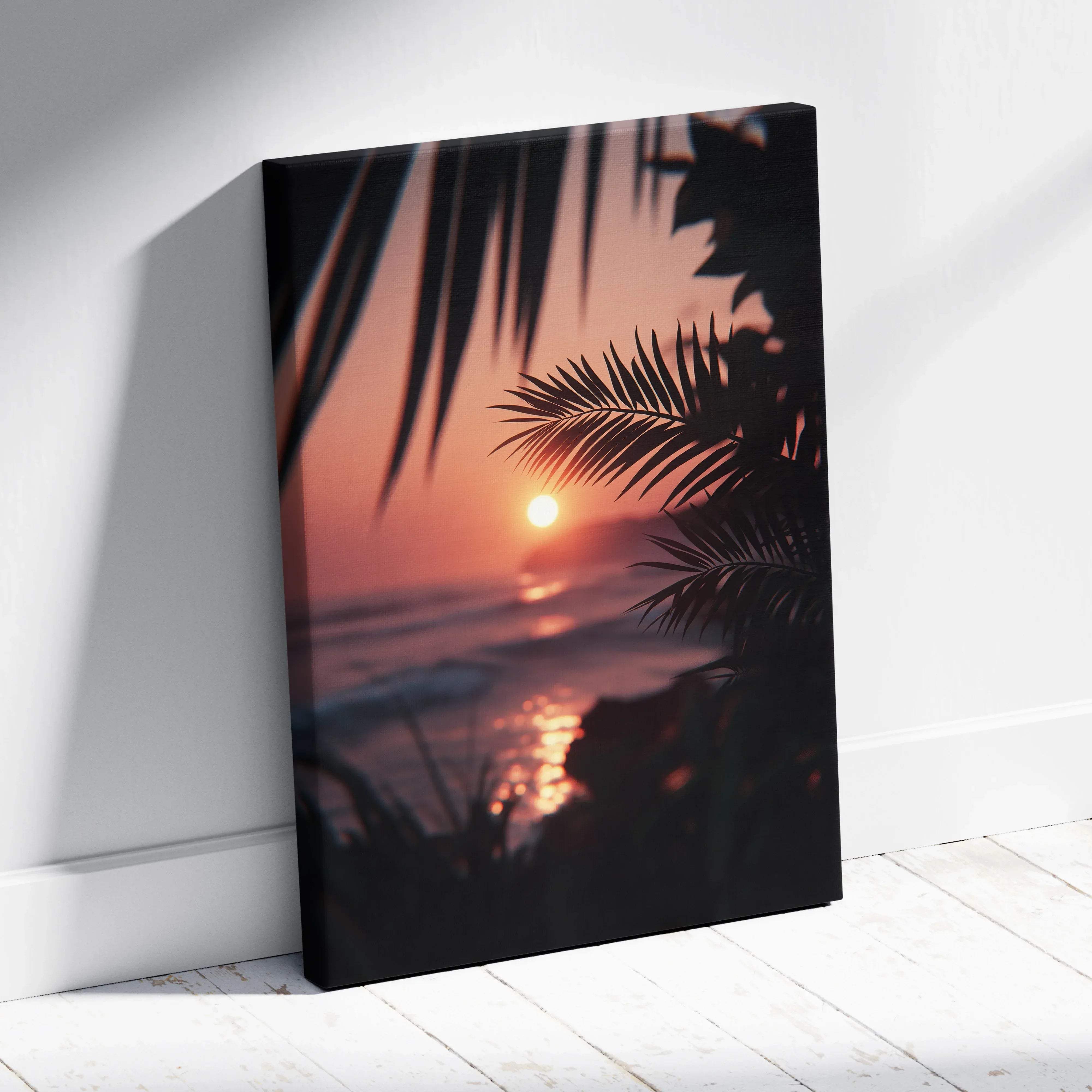 A framed canvas print of tropical sunset wall art with silhouetted palm leaves in warm amber and pink hues