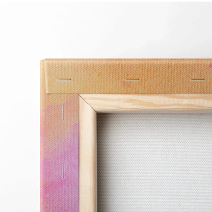 Close-up of wooden frame corner with staples securing stretched canvas featuring soft pink and peach abstract digital art on