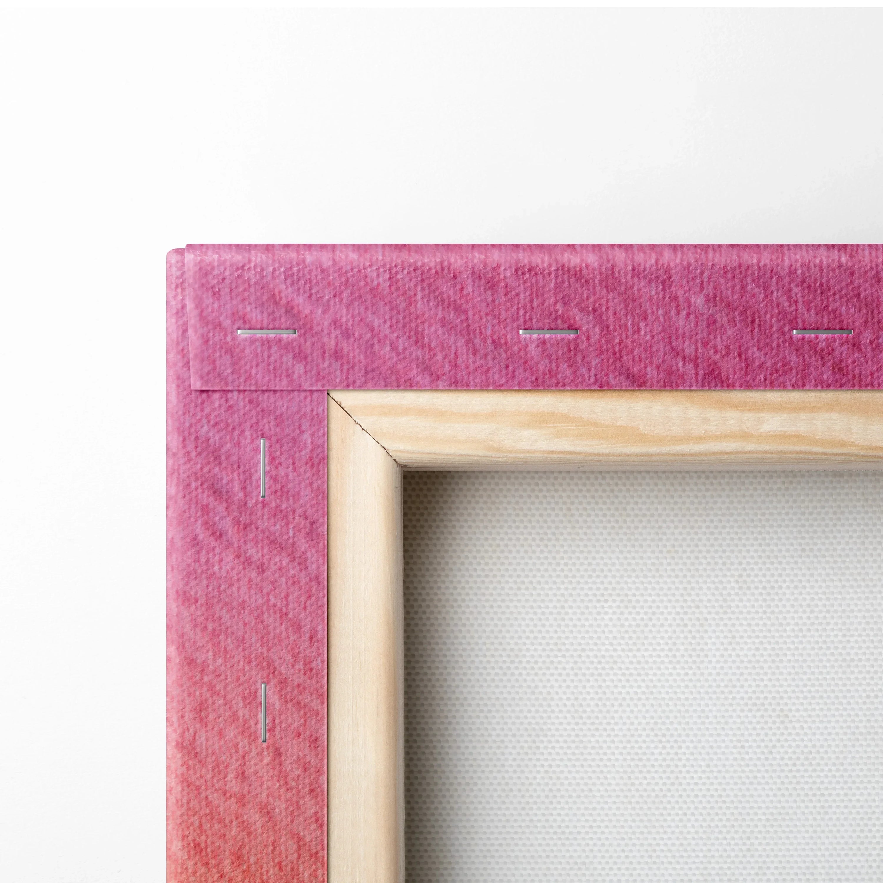 Close-up of stretched canvas corner with pink gradient fabric and wooden frame for wall art.