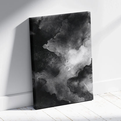 Black and white abstract digital art canvas with smoky, cloud-like textures leaning against white wall wall art.
