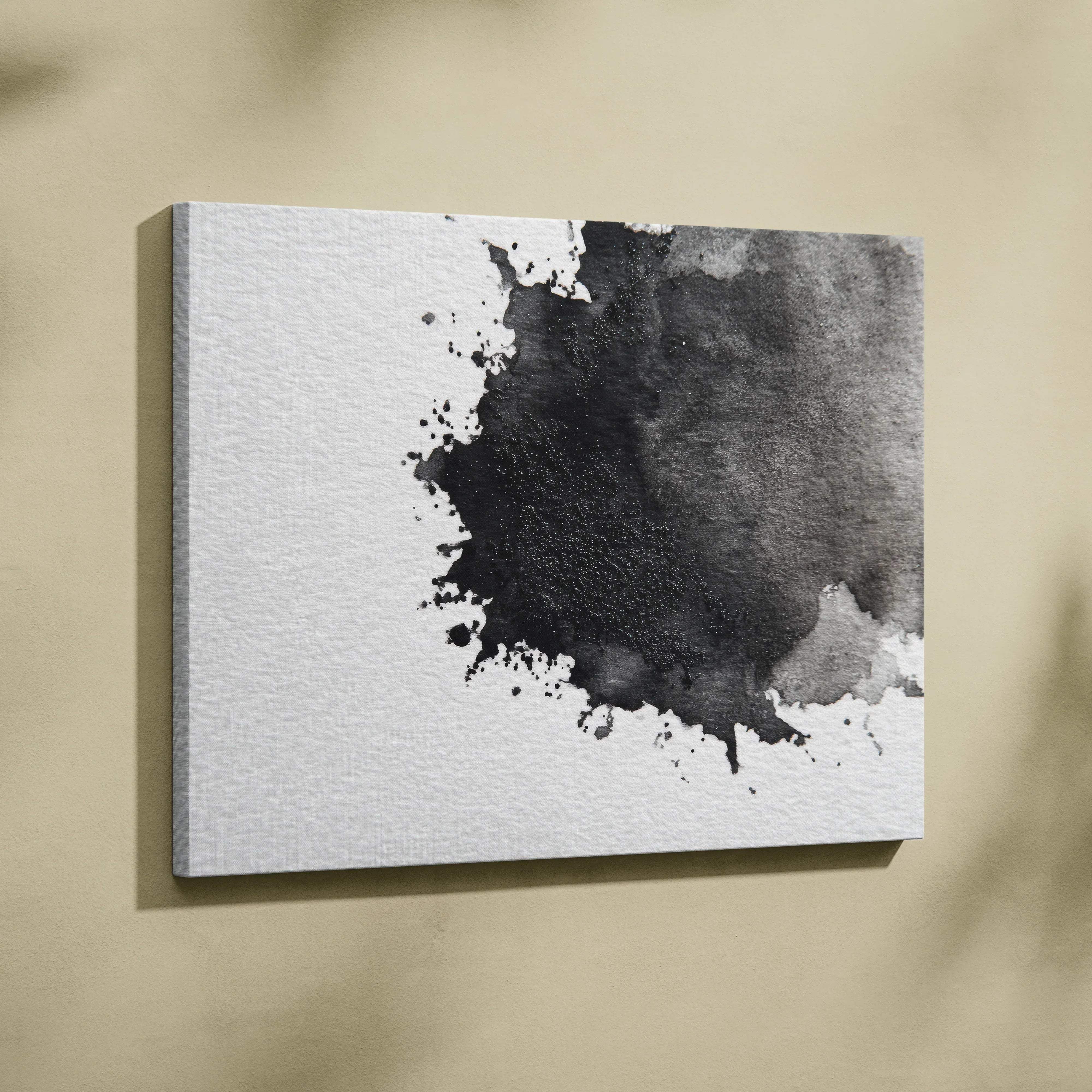 A minimalist black and white abstract ink splatter canvas wall art on textured white fabric for moody living room decor