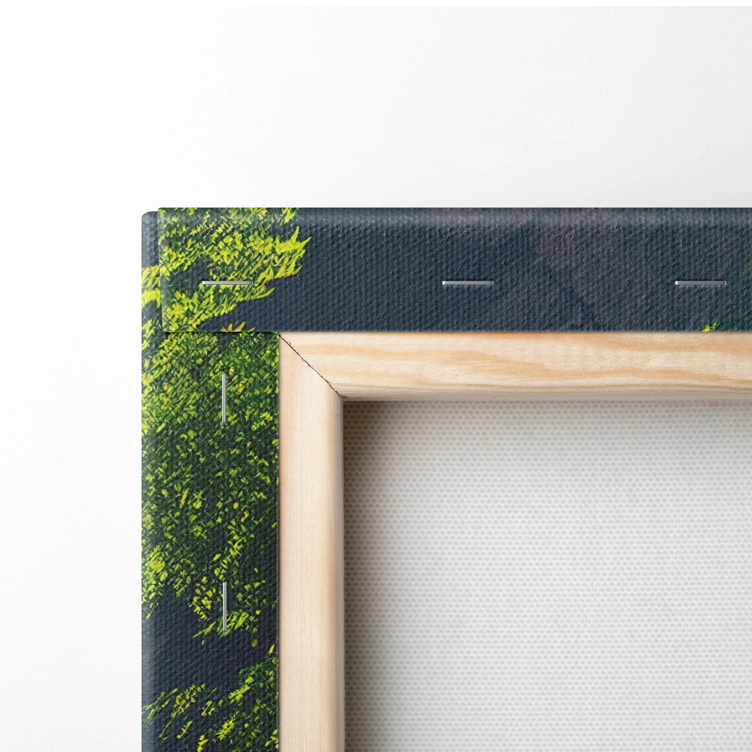 Close-up of wooden frame corner on canvas wall art showing green forest and waterfall print.