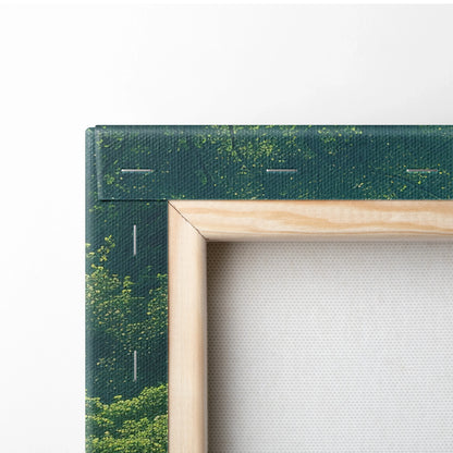 Close-up of stretched canvas with dark green forest print and natural wood frame for wall art decor.