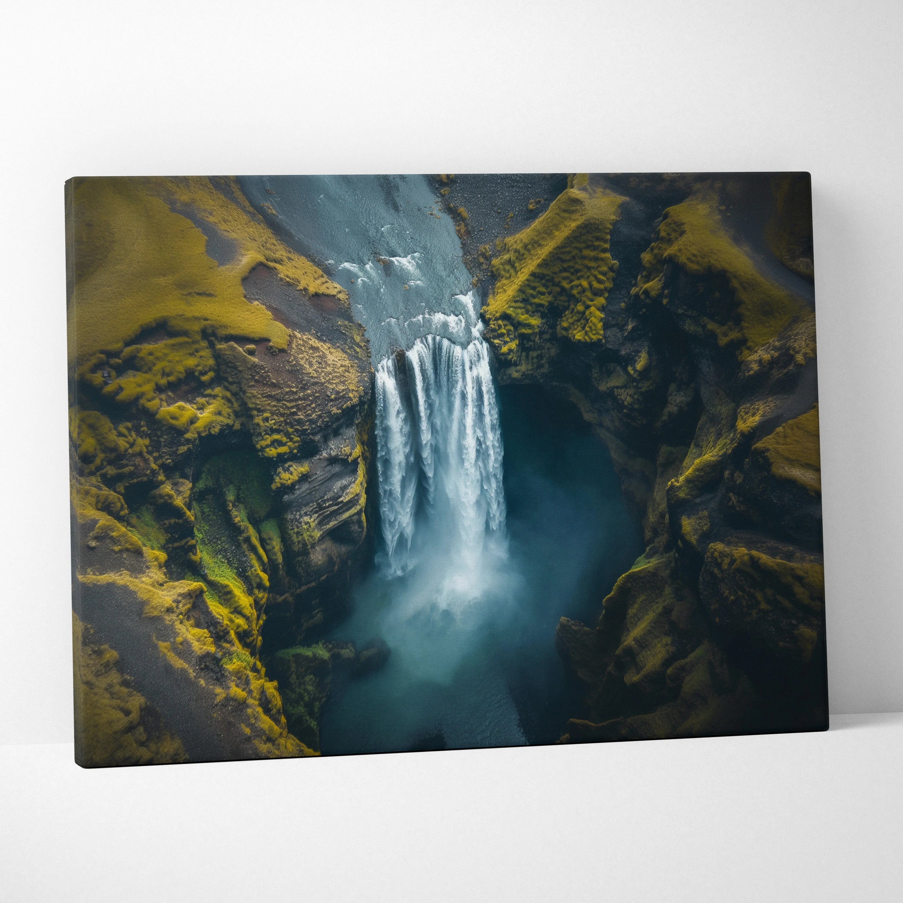 Canvas wall art depicting a high-resolution waterfall cascading through rugged mossy cliffs in earthy green and blue tones.