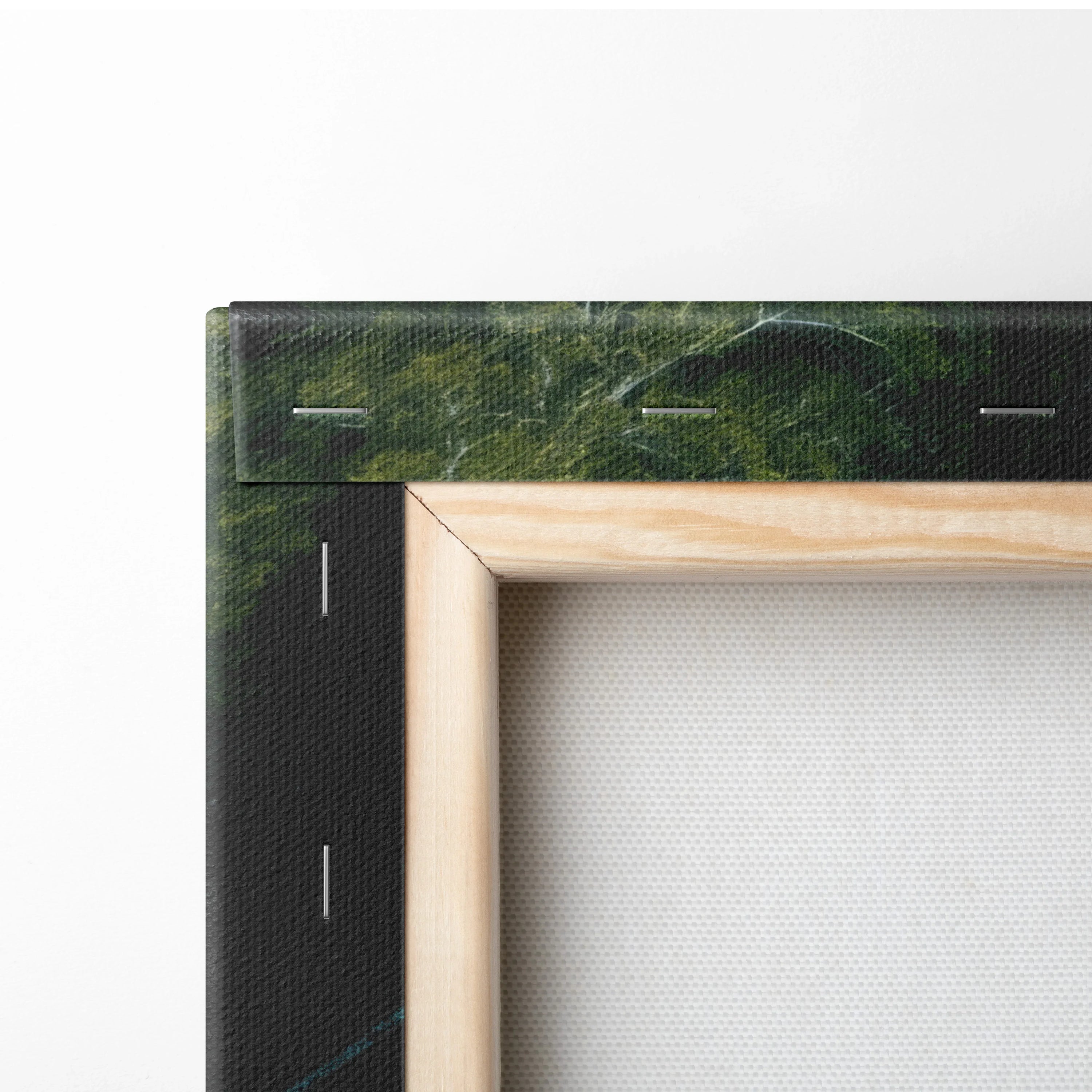 Close-up of wooden frame corner with stretched canvas featuring dark green forest and waterfall print wall art decor.