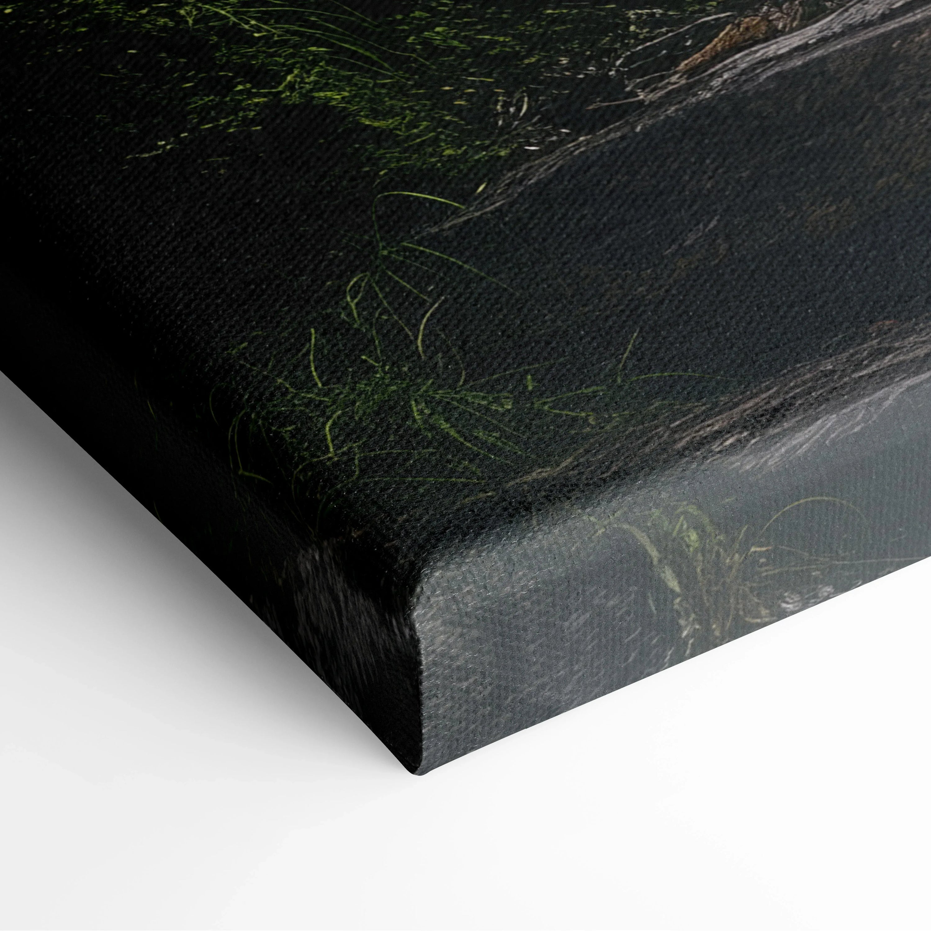 Close-up of canvas wall art corner showing textured edge with dark green forest and waterfall details on a smooth surface.
