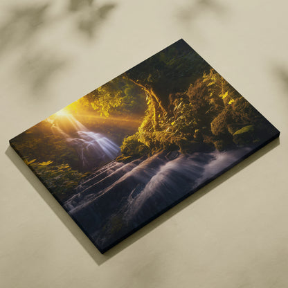 Sunlit waterfall cascading over mossy rocks in a lush forest, printed on textured canvas wall art.